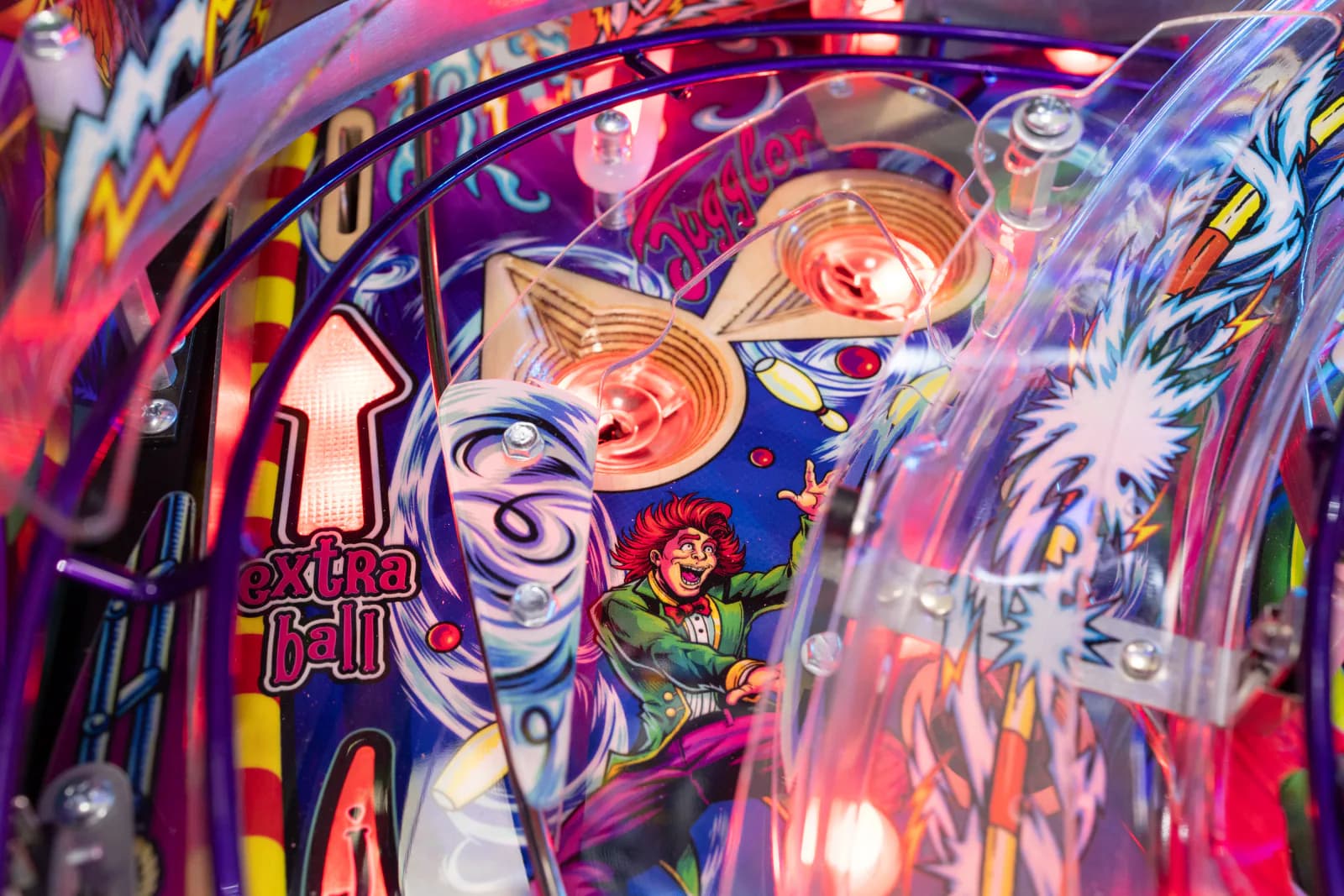 Pop bumpers lit red beside the juggler artwork