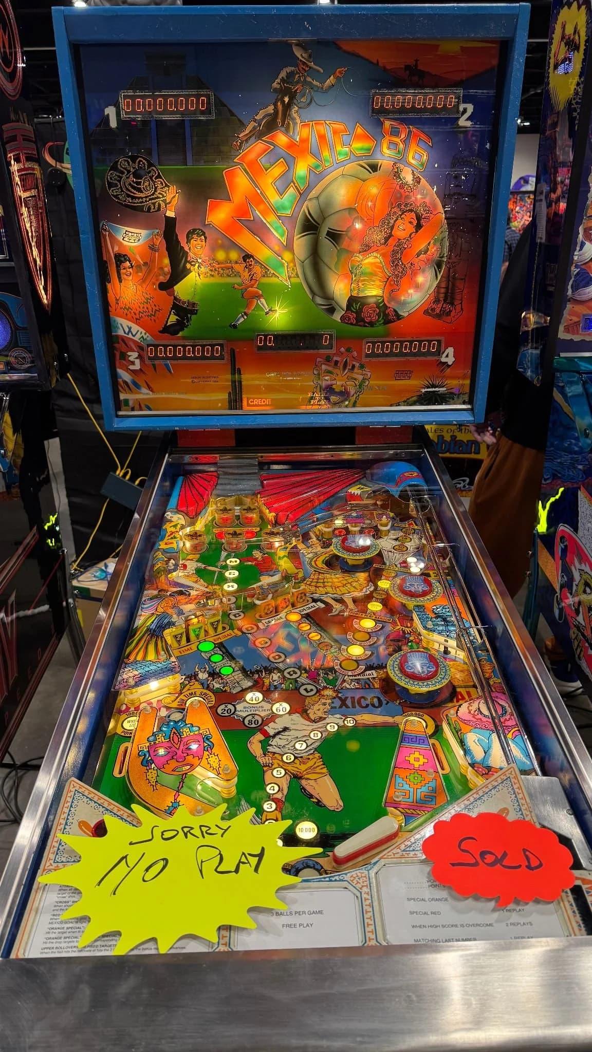 A pinball machine marked sold, with a no-play sign on its glass