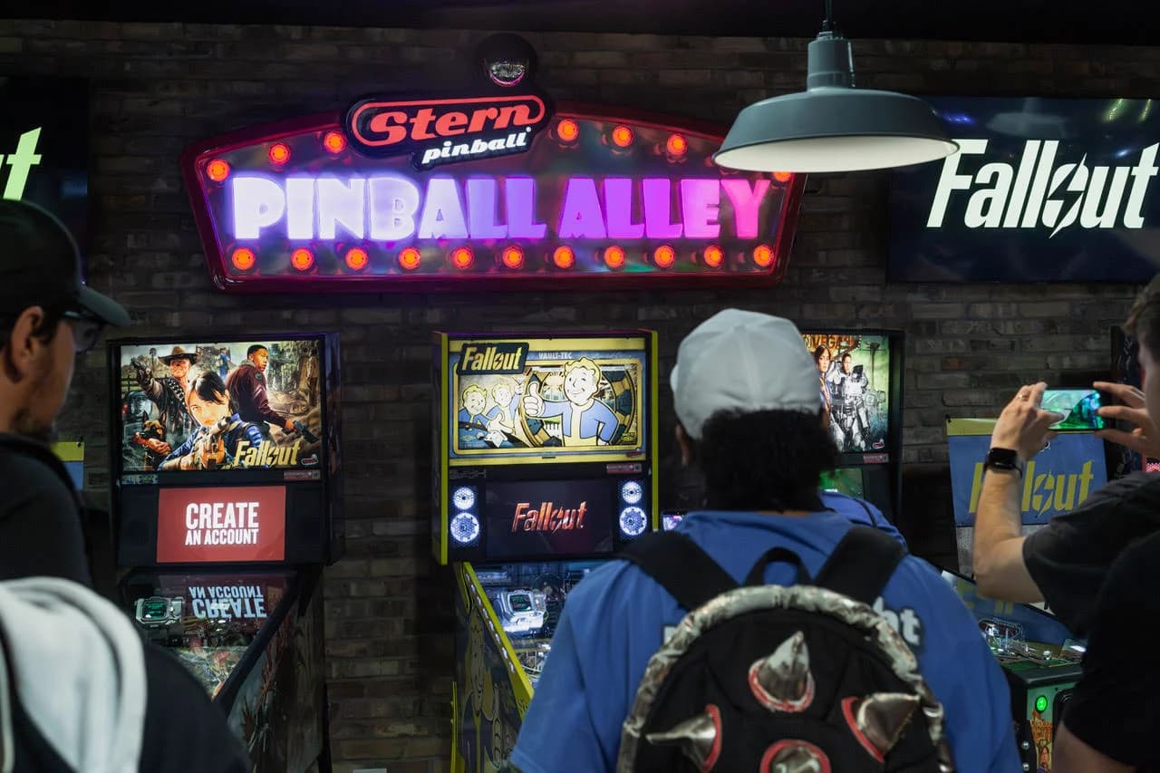 Steven Bowden, in a white cap, waiting at the Fallout Premium under Stern's Pinball Alley sign at media day