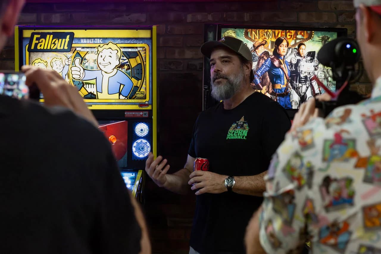 Keith Elwin, in a Stern Pinball shirt and cap, talking to media in front of the Fallout Limited Edition backglass