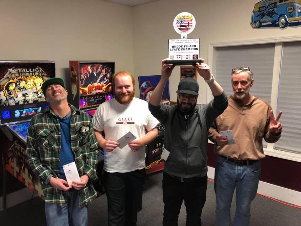 Four men pose with Rhode Island State Champion pinball trophy