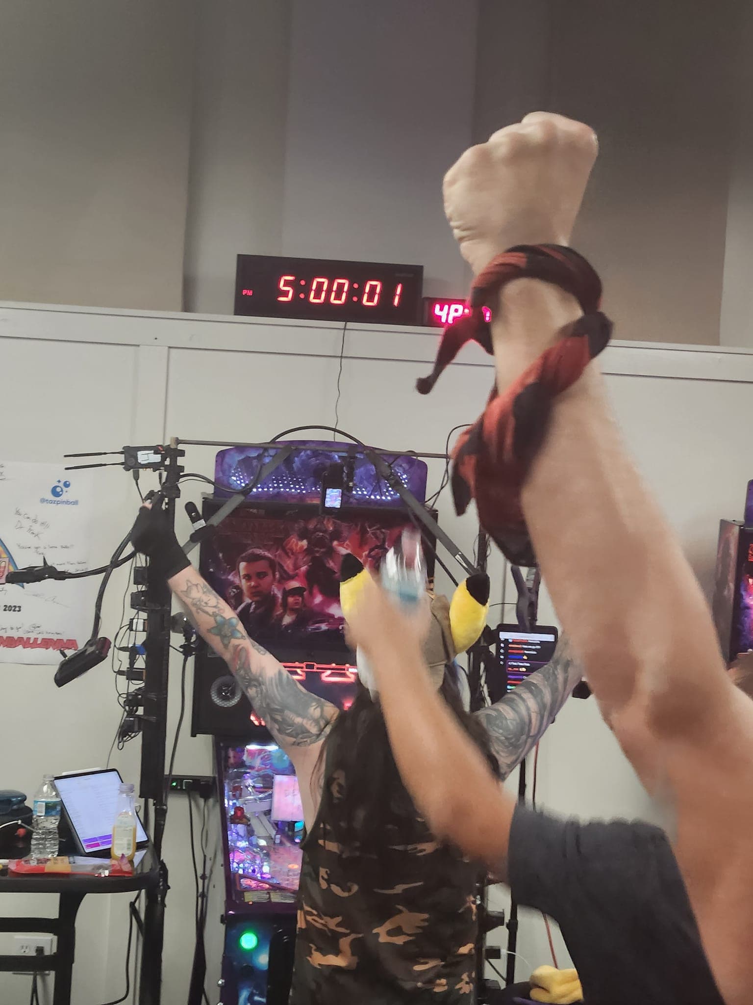 Gamer with raised fists celebrating in front of gaming setup with timer