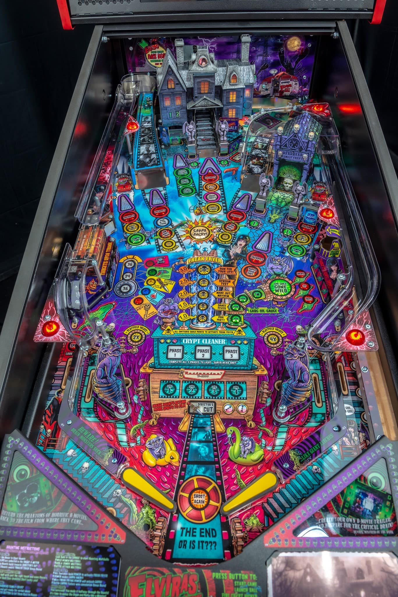 Colorful Halloween-themed pinball machine with haunted house and spooky details