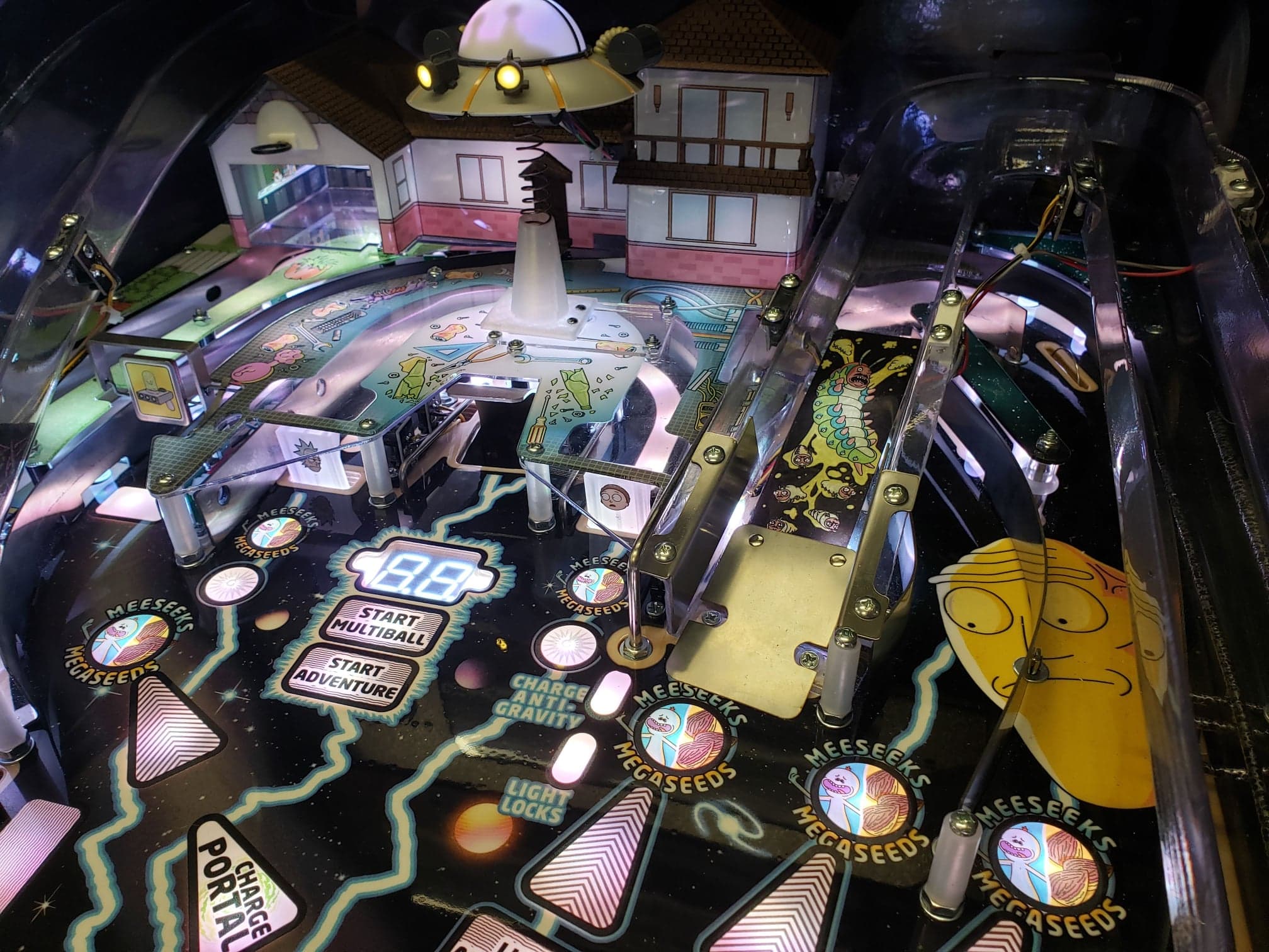 Colorful Rick and Morty pinball machine with UFO and suburban house
