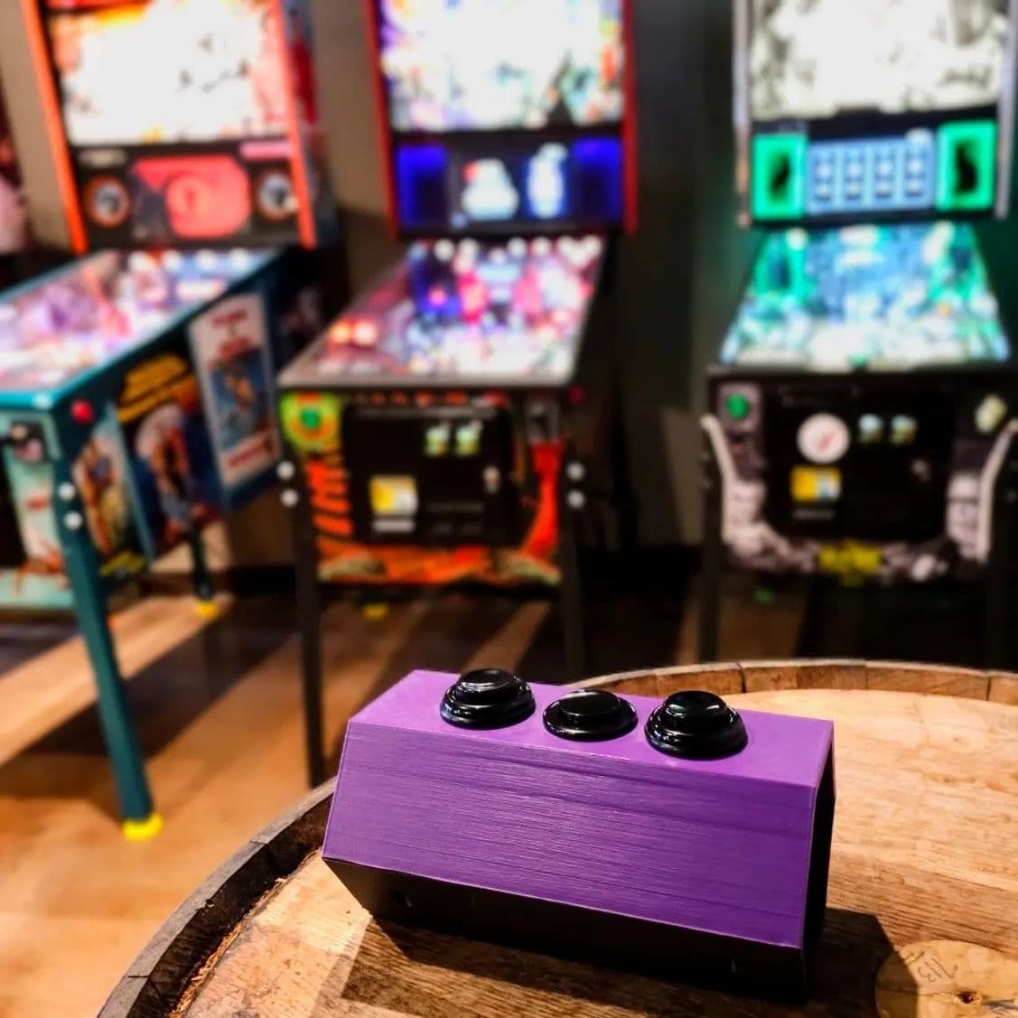 Purple control block with three black buttons on arcade game machines