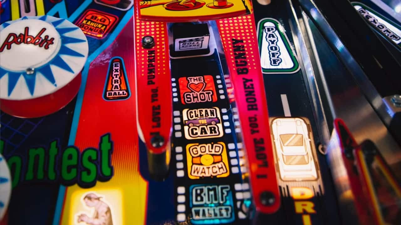 Colorful vintage pinball machine with retro game labels and graphics