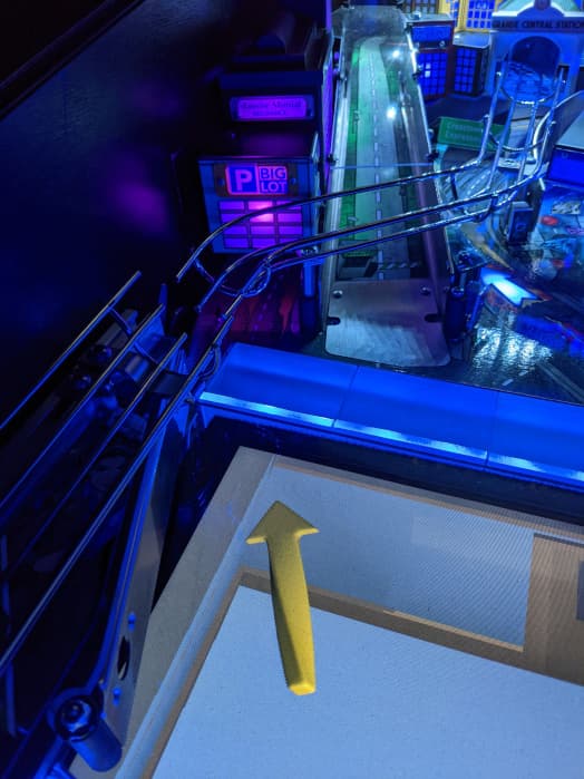 Blue-lit industrial scene with yellow arrow and metallic walkways