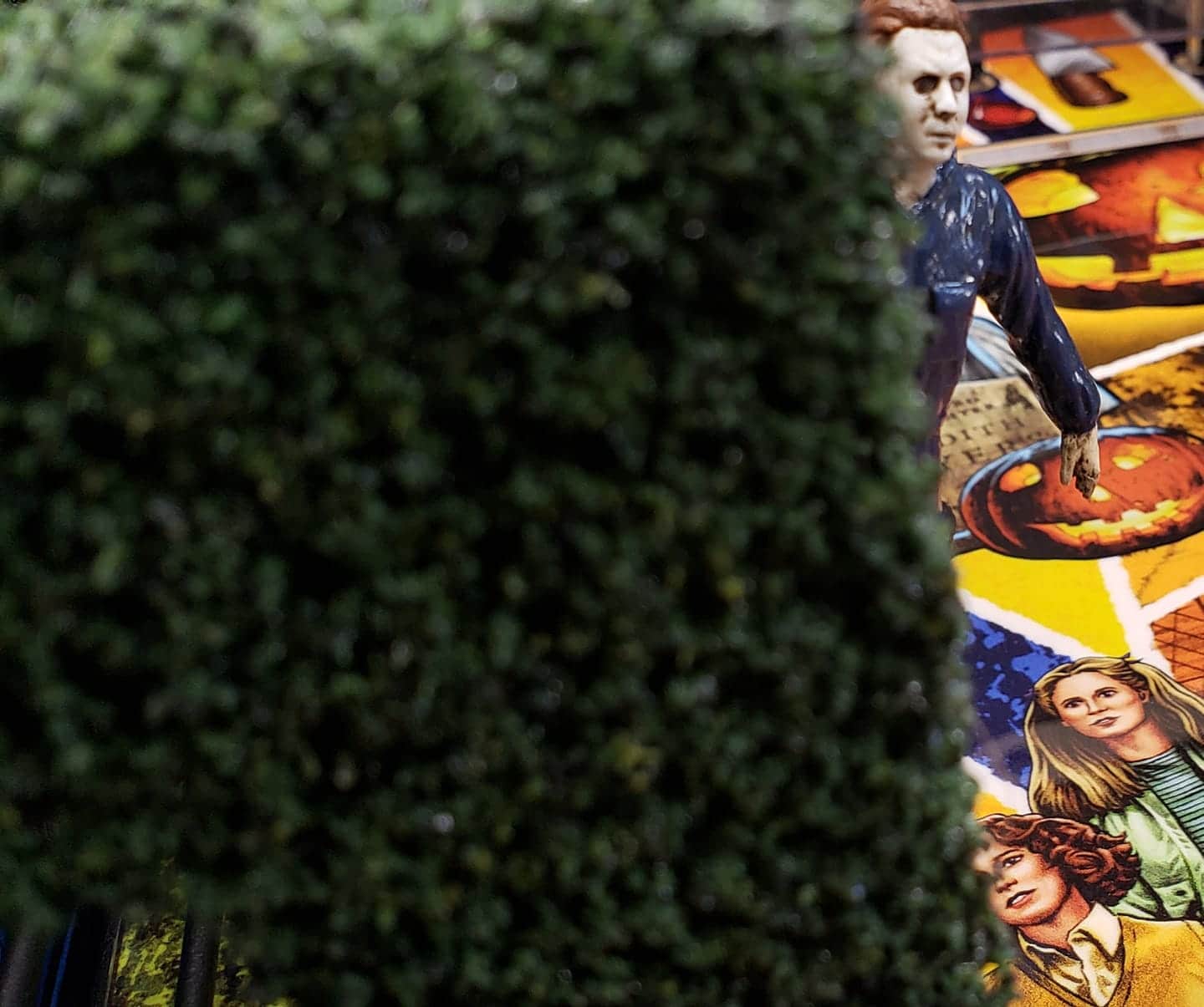 Halloween scene with Michael Myers near jack-o'-lantern and movie poster