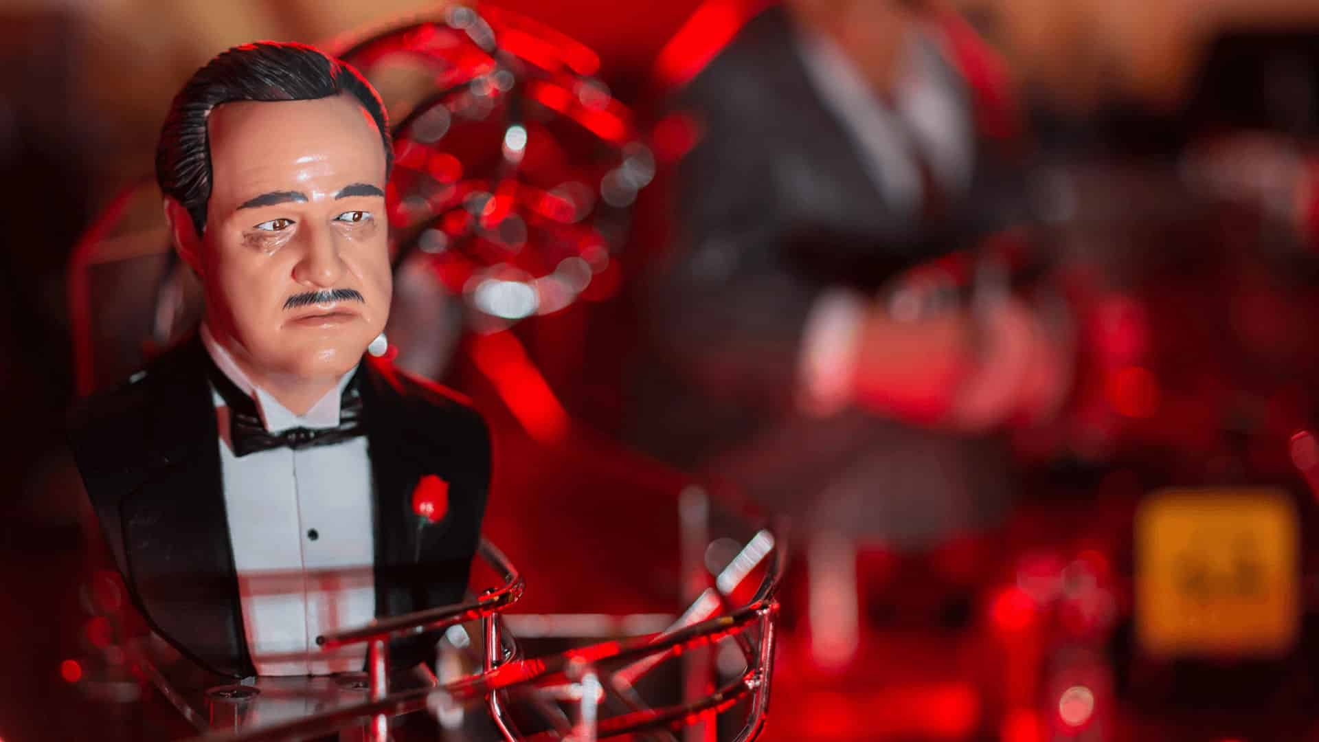 Vintage bobblehead figurine in tuxedo with red dramatic lighting