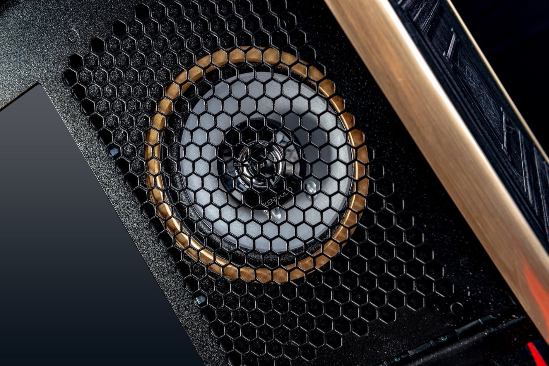 Honeycomb-patterned speaker grille with metallic gold and black design