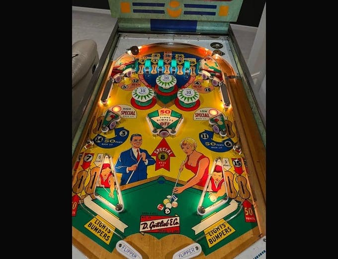 Bank-A-Ball playfield lit, its pool-hall art and lit bumpers visible, D. Gottlieb & Company, 1965
