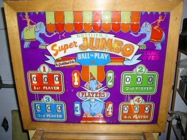 The Super Jumbo backglass, with four numbered player score reels around a circus elephant and a row of lit ball-in-play indicators across the top