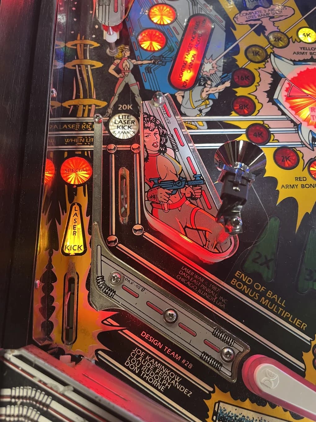 The Laser Kick left outlane with its arrow insert lit and the LITE LASER KICK & RAMP target above it