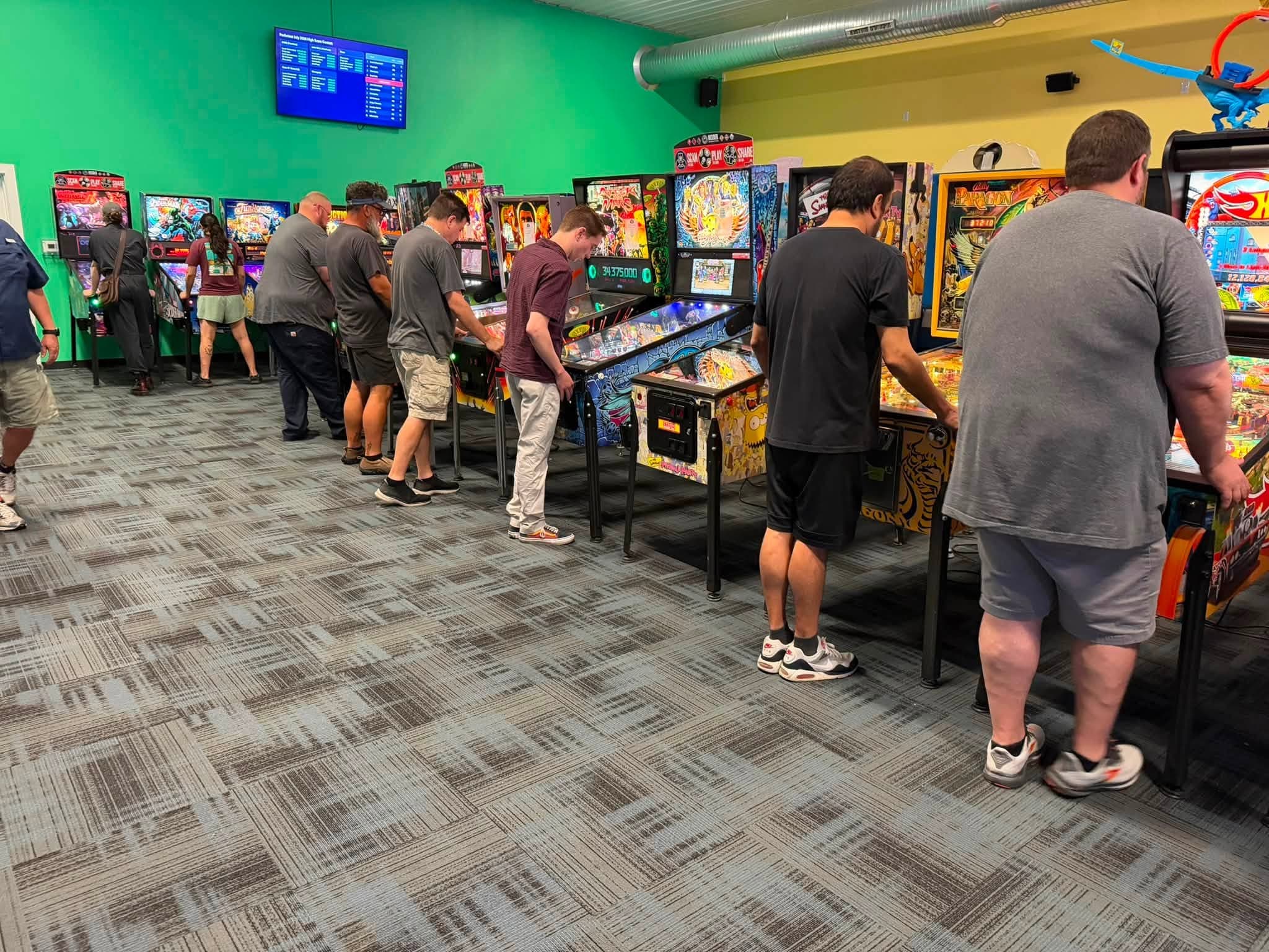 Players competing on a bank of pinball machines at Pocketeer Billiards and Bar in Buffalo, New York