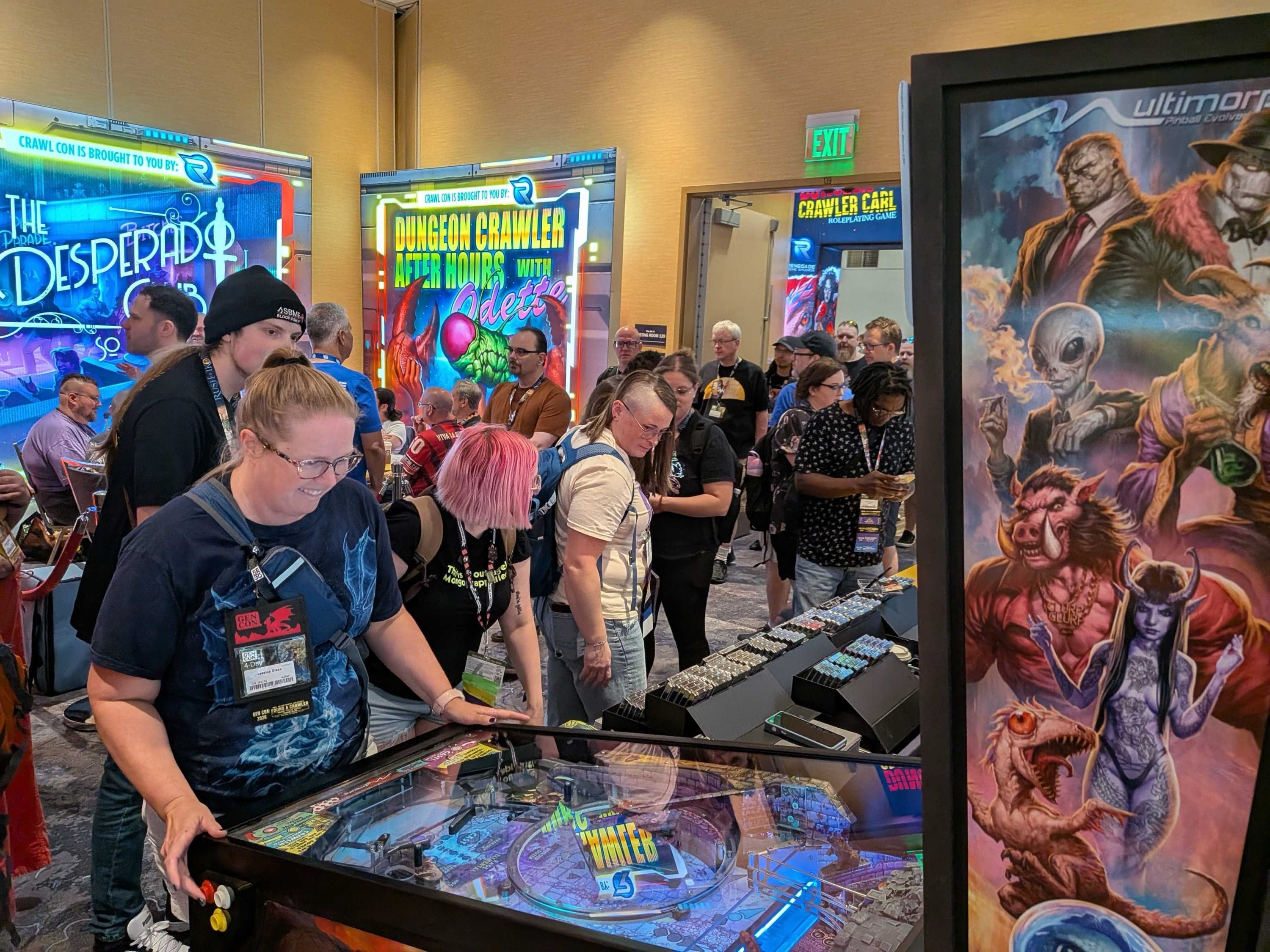 A crowd around a Dungeon Crawler Carl pinball machine, several attendees in costume