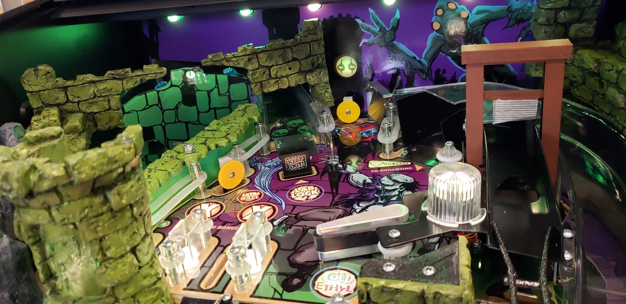 Pinball machine with green stone walls and colorful fantasy-themed playfield