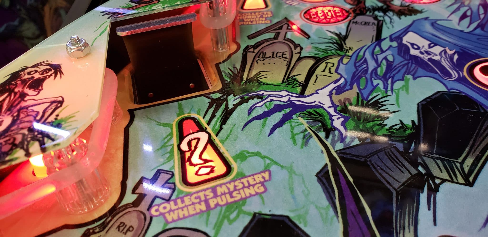 Spooky pinball machine with gravestones, mystery pulsing, and colorful lights