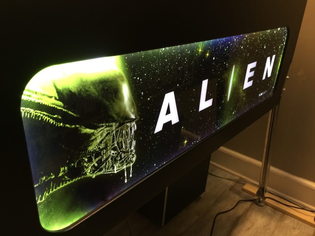 Alien movie logo with xenomorph creature on starry background