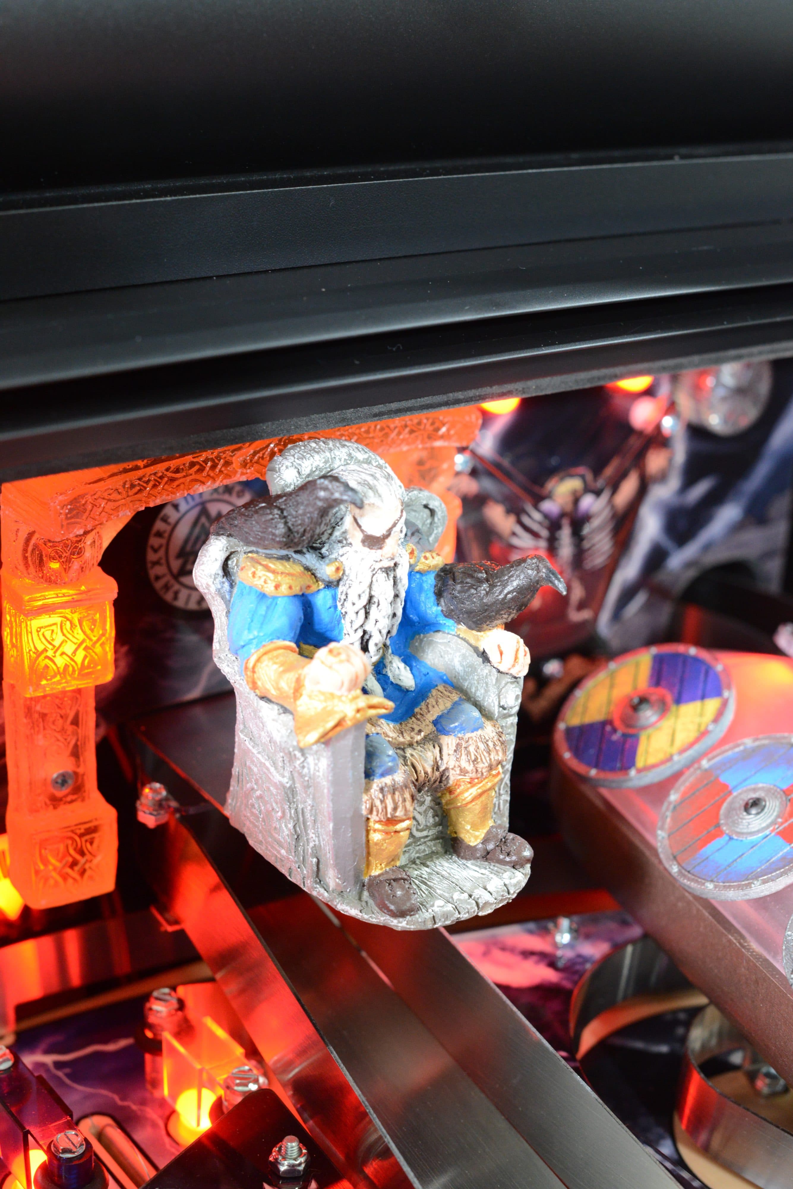 Dwarf figurine with blue coat sitting on stone throne surrounded by warm lights