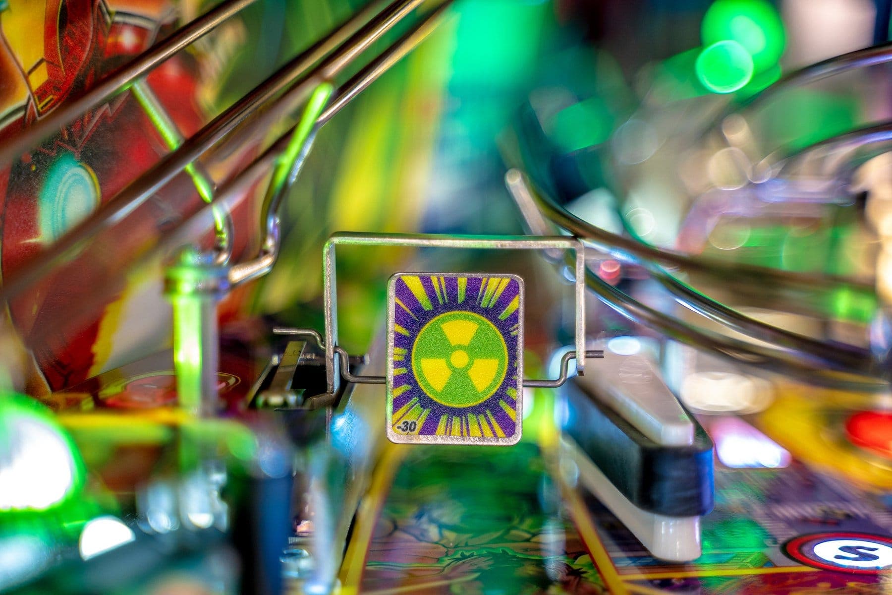 Radioactive warning symbol on colorful pinball machine detail