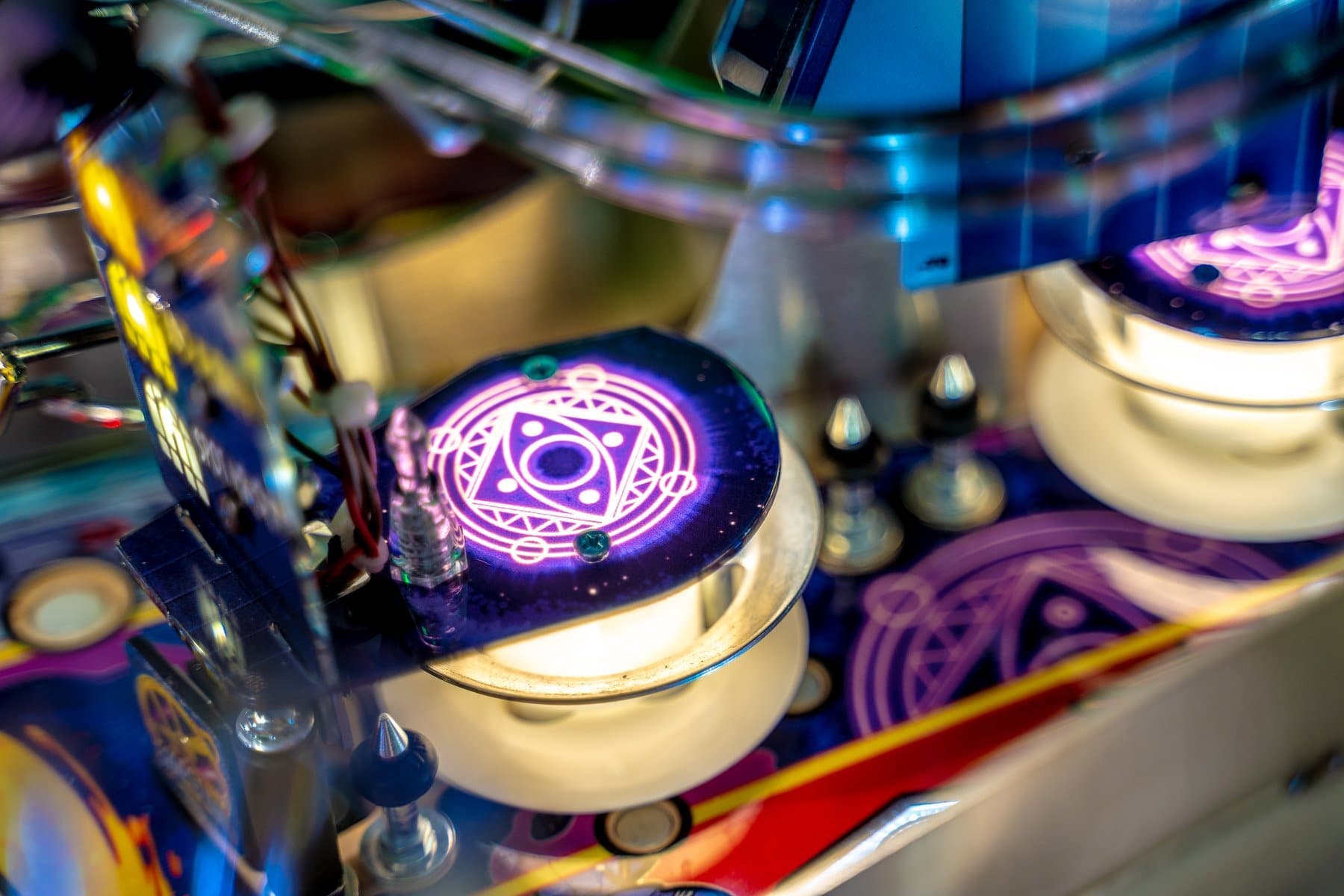 Glowing magical circle with intricate design on colorful pinball machine component