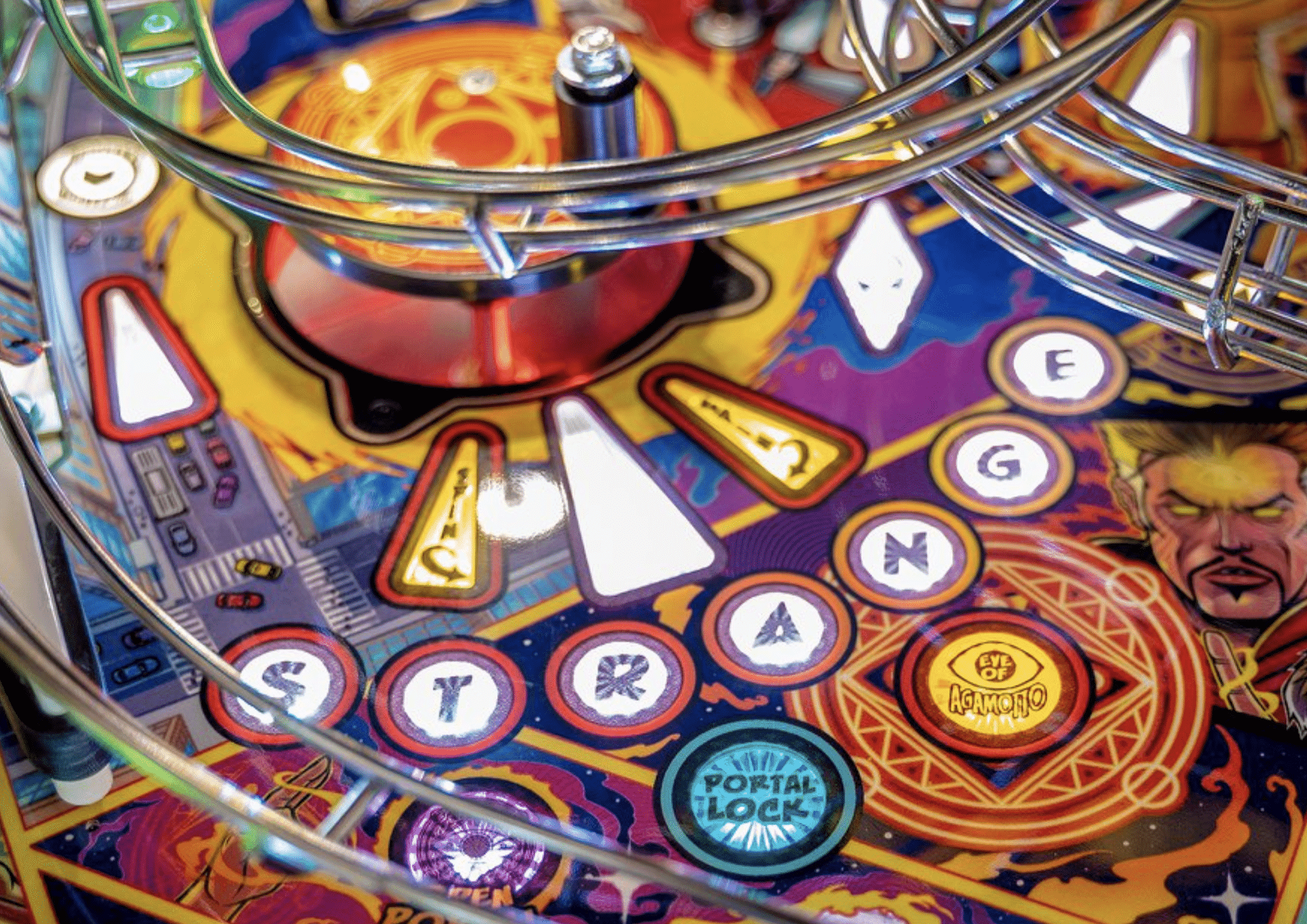 Colorful pinball machine with glowing letters, portal, and intricate chrome rails