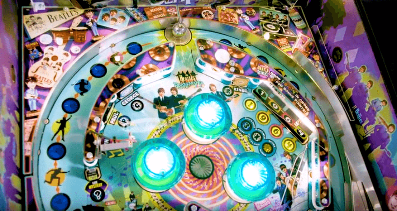 The Beatles pinball machine with colorful design and glowing blue flippers