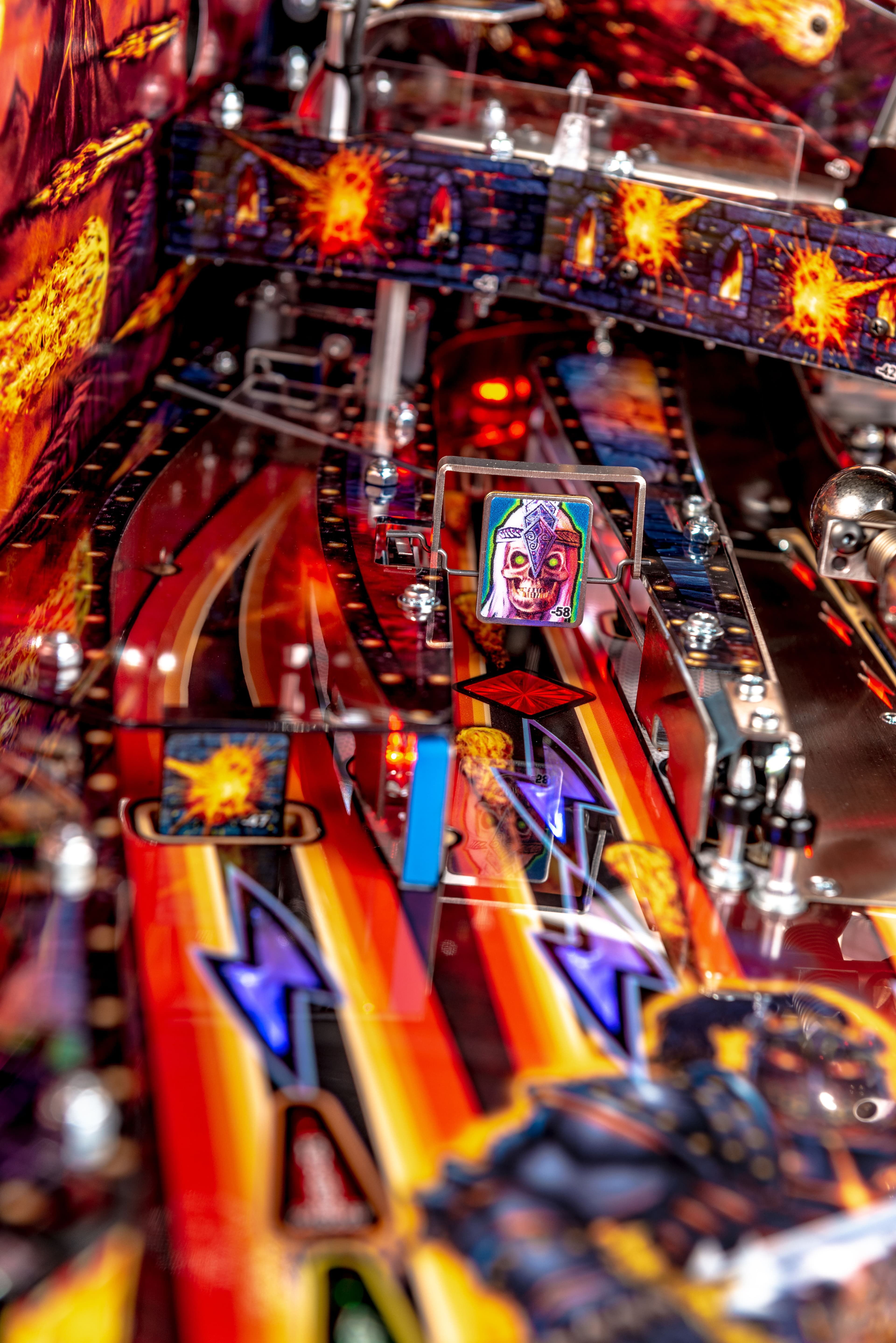 Colorful pinball machine with intricate details and fiery red-orange backdrop