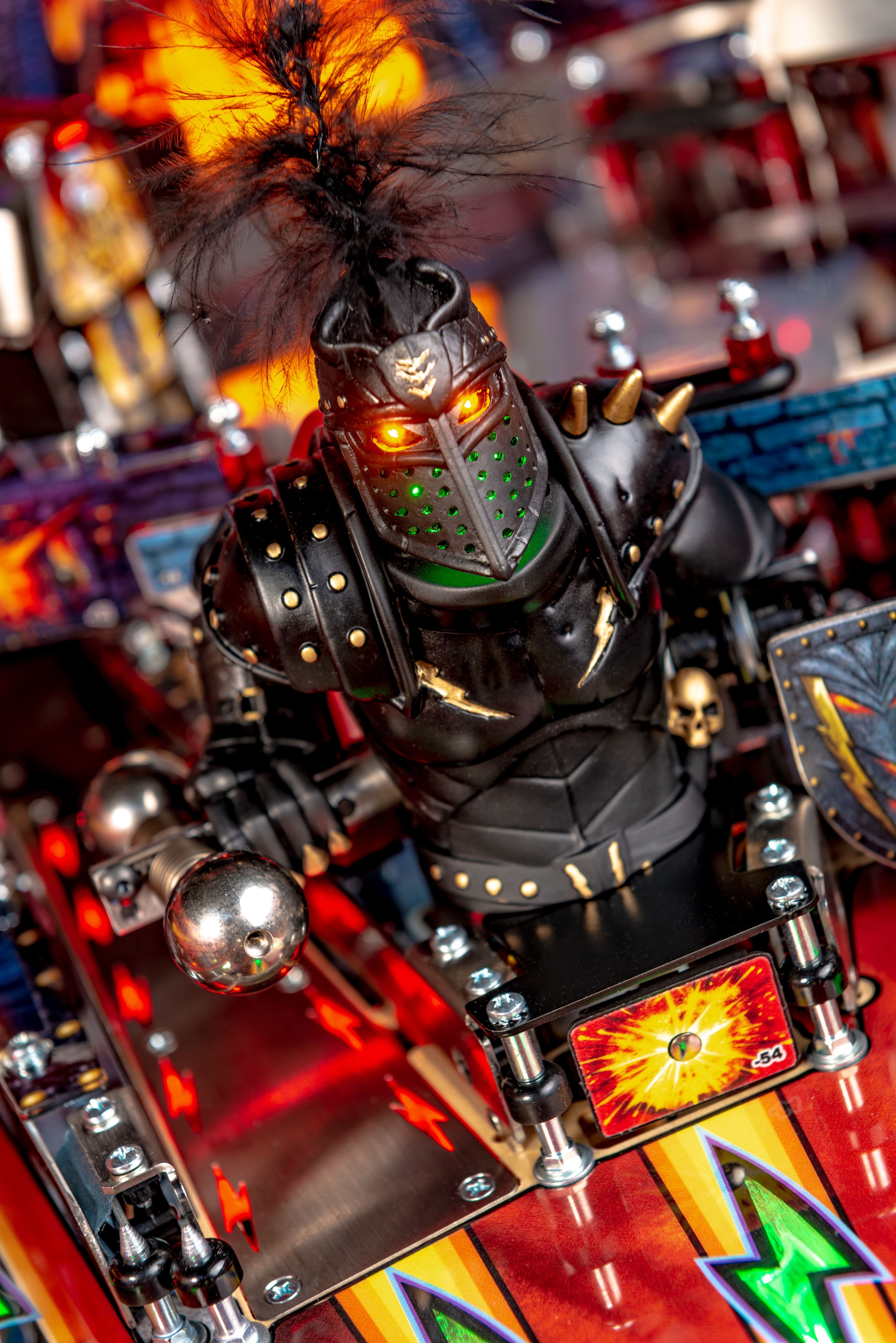 Glowing-eyed robotic knight on a colorful pinball machine backboard