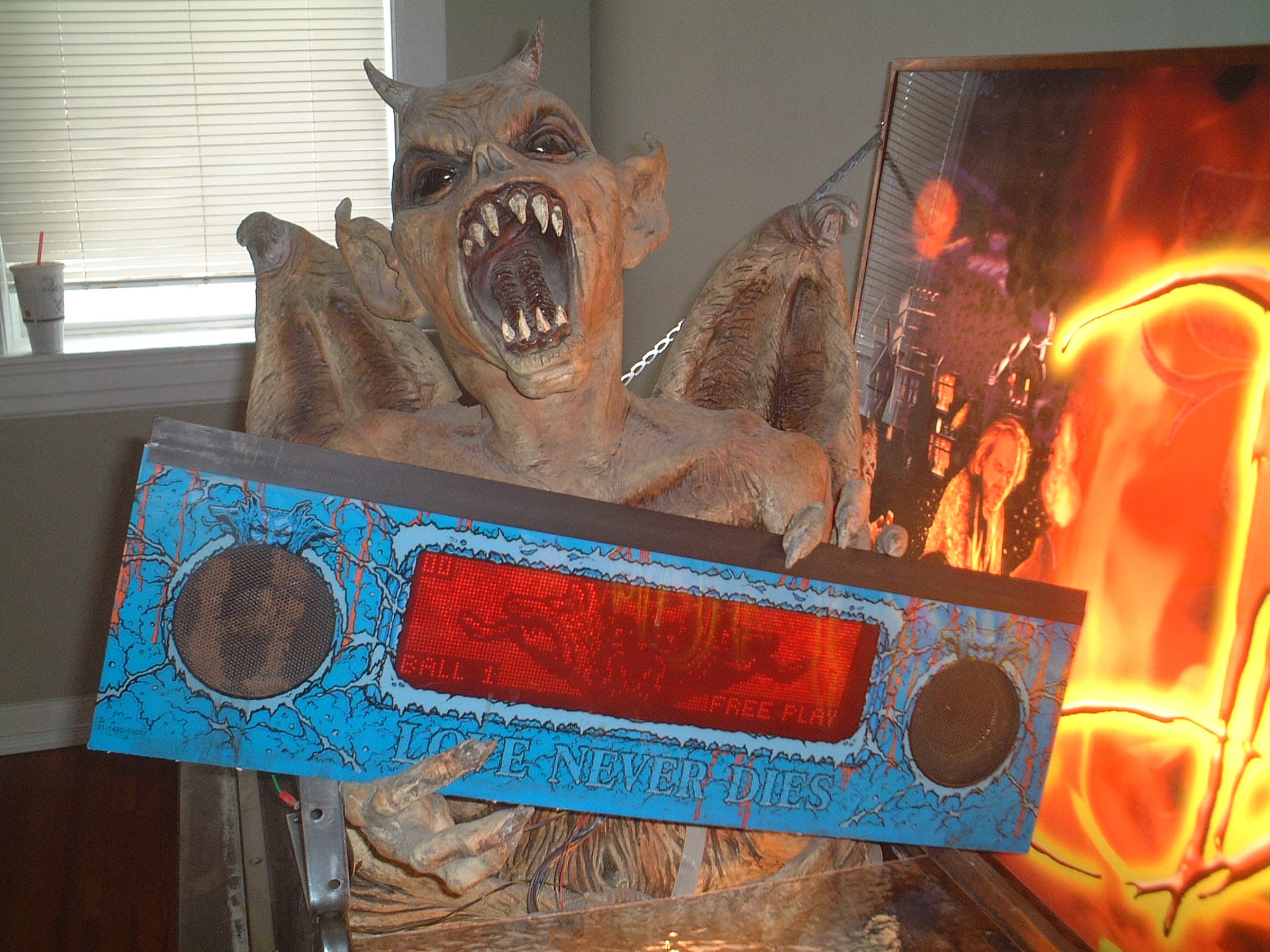 Scary monster prop with sharp teeth next to a blue Lost Boys sign