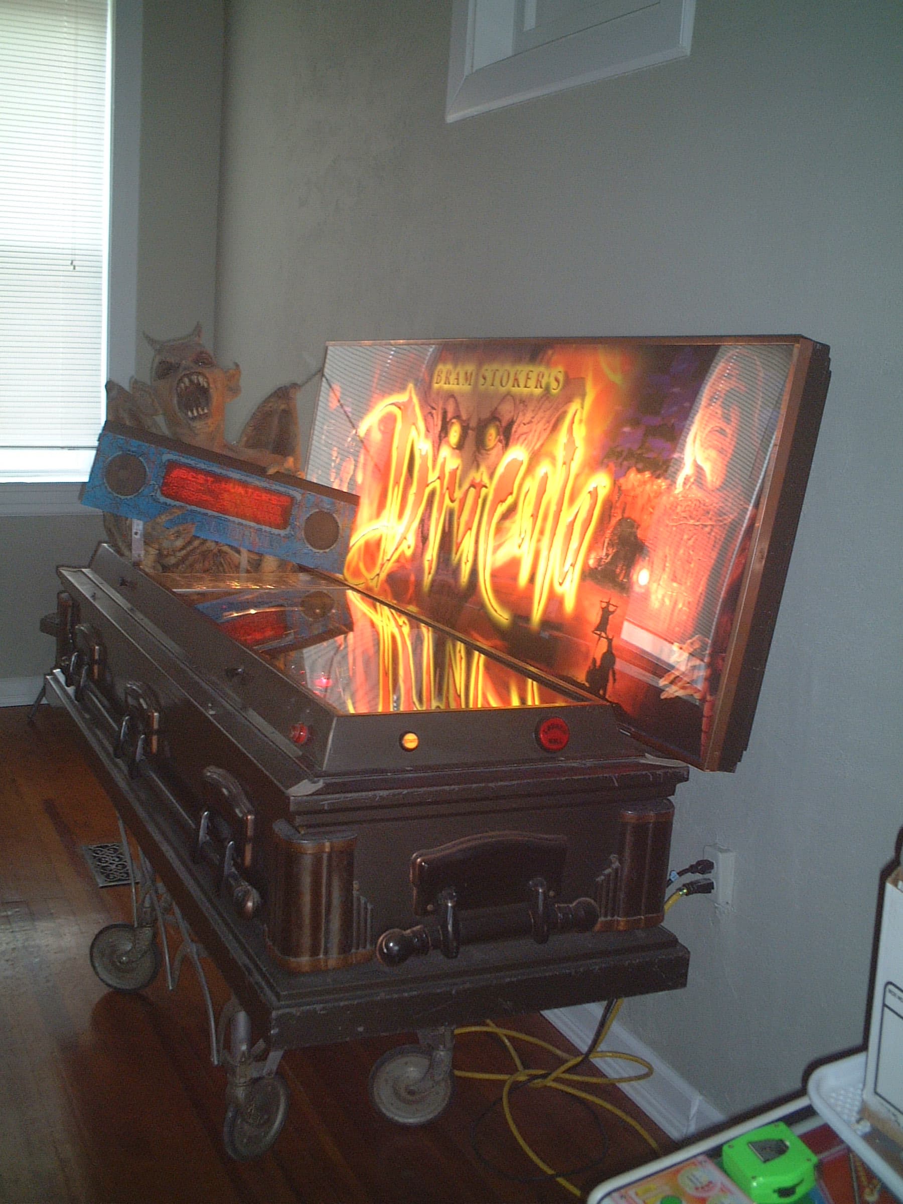 Vintage Dracula pinball machine with fiery backglass on old wheeled stand