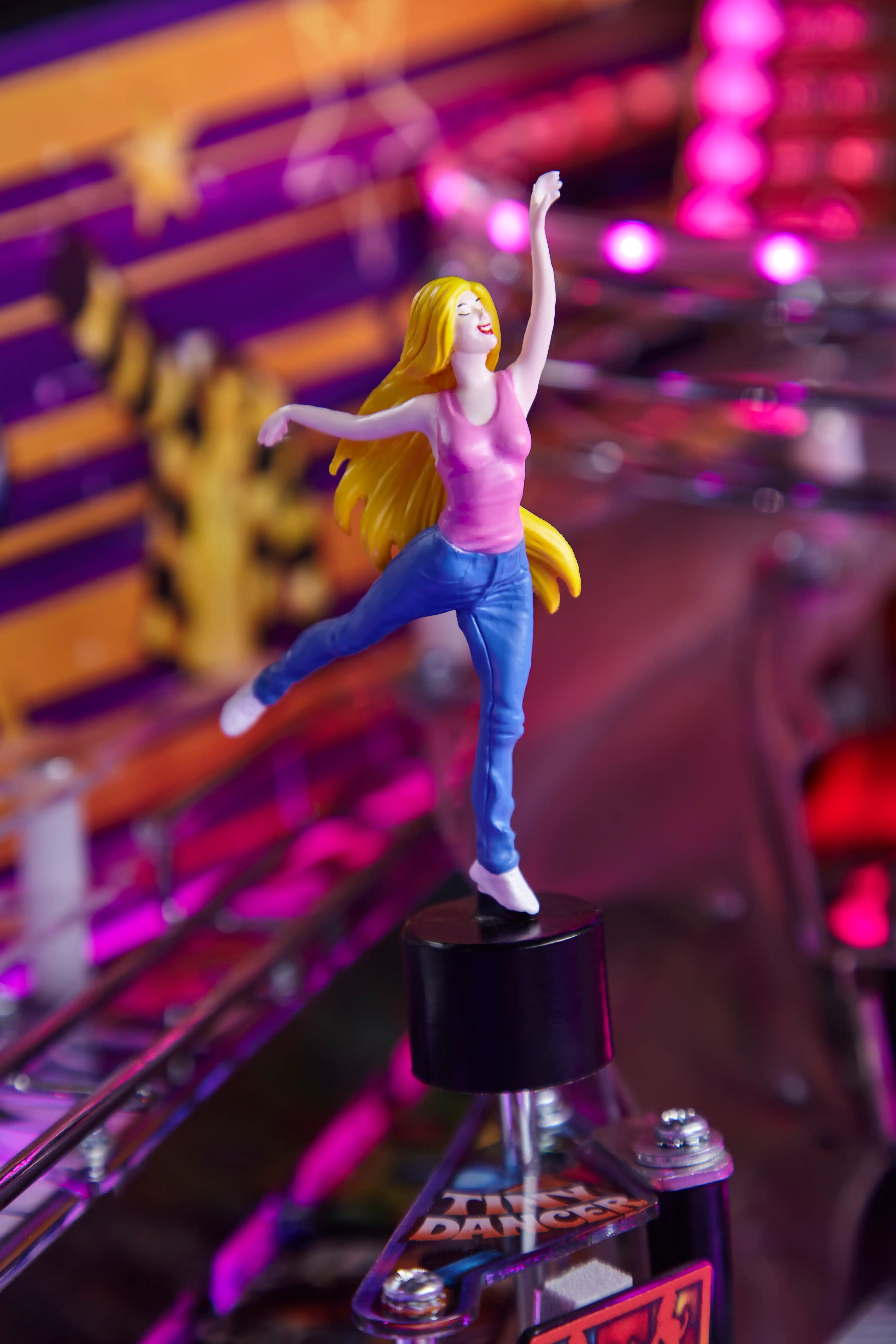Figurine of a dancing woman on a pinball machine with colorful lights