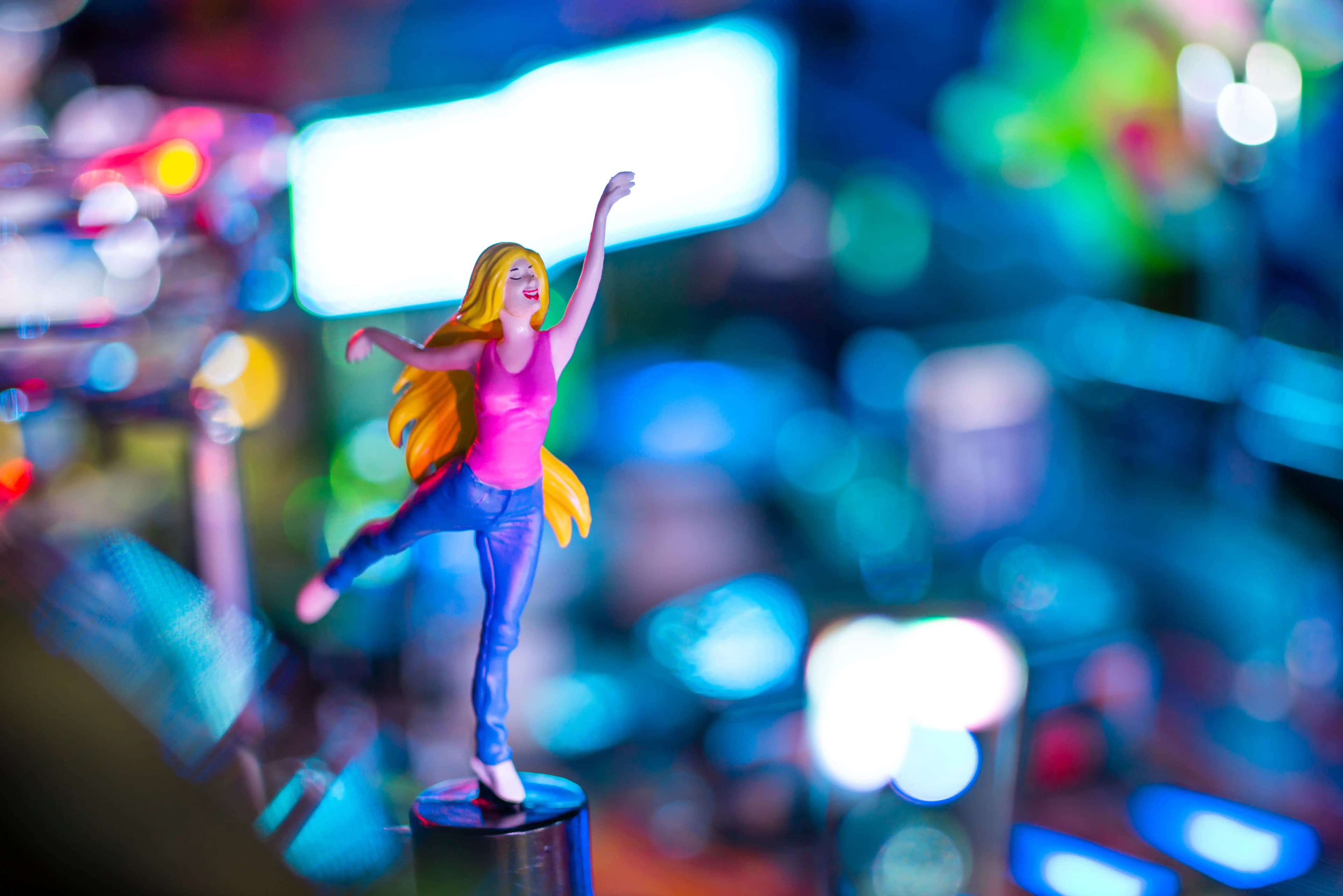 Colorful figurine of dancing woman with blurred bokeh lights background