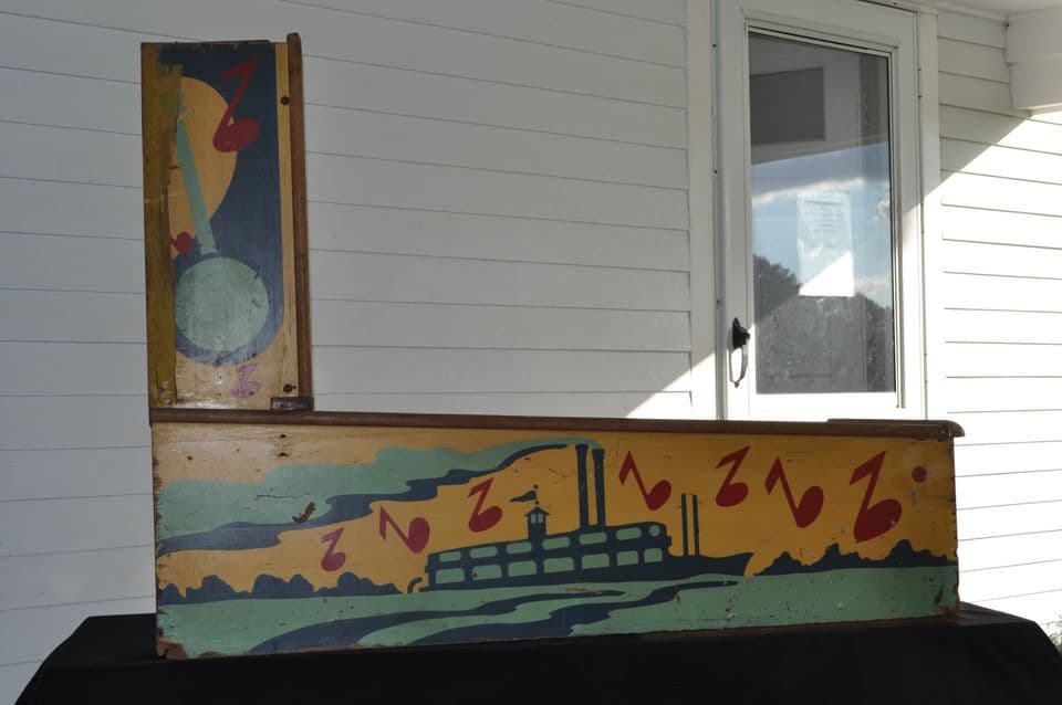 Vintage wooden sign with colorful steamboat and musical notes