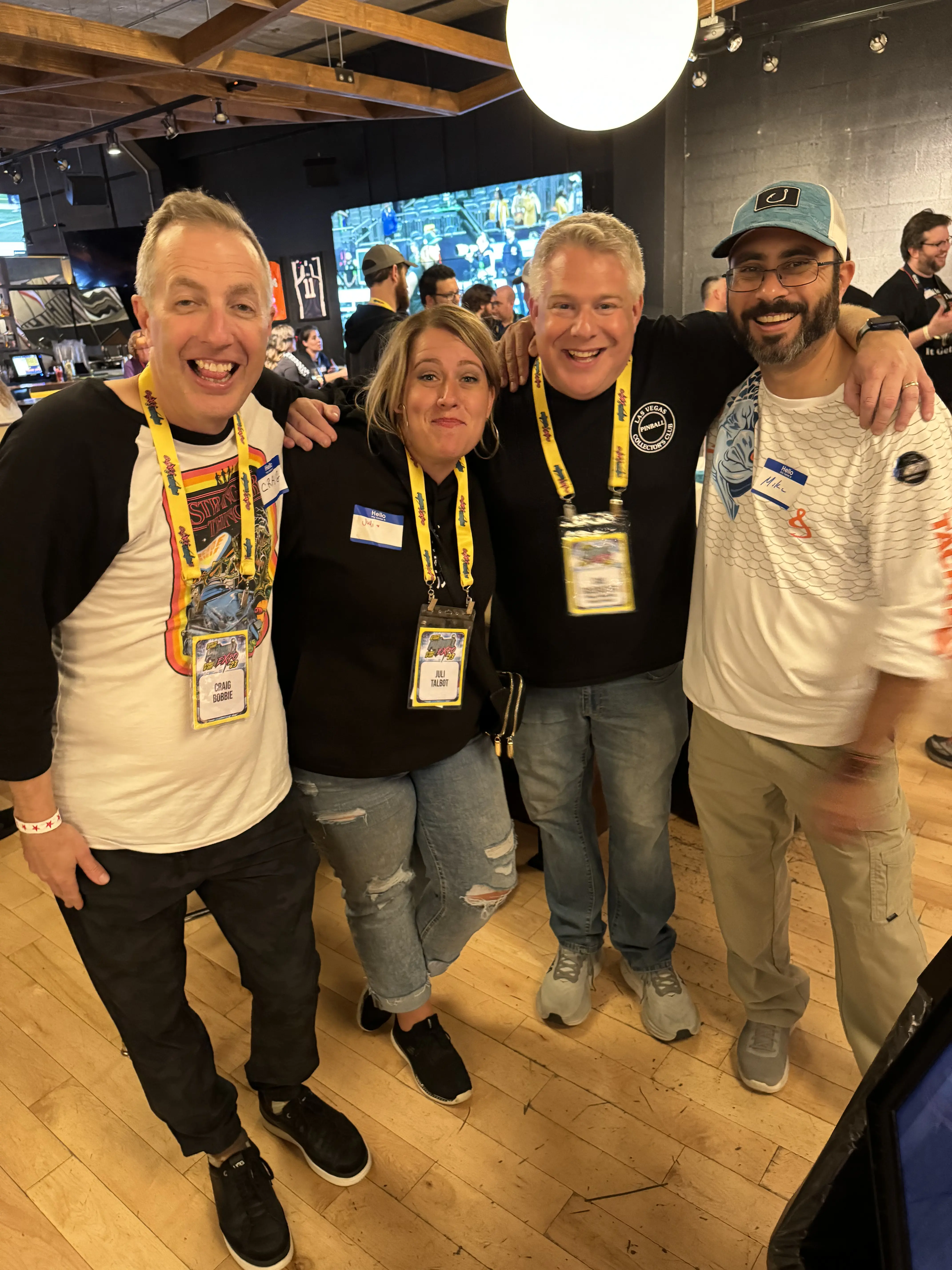 Four conference attendees smiling together, wearing name badges and lanyards