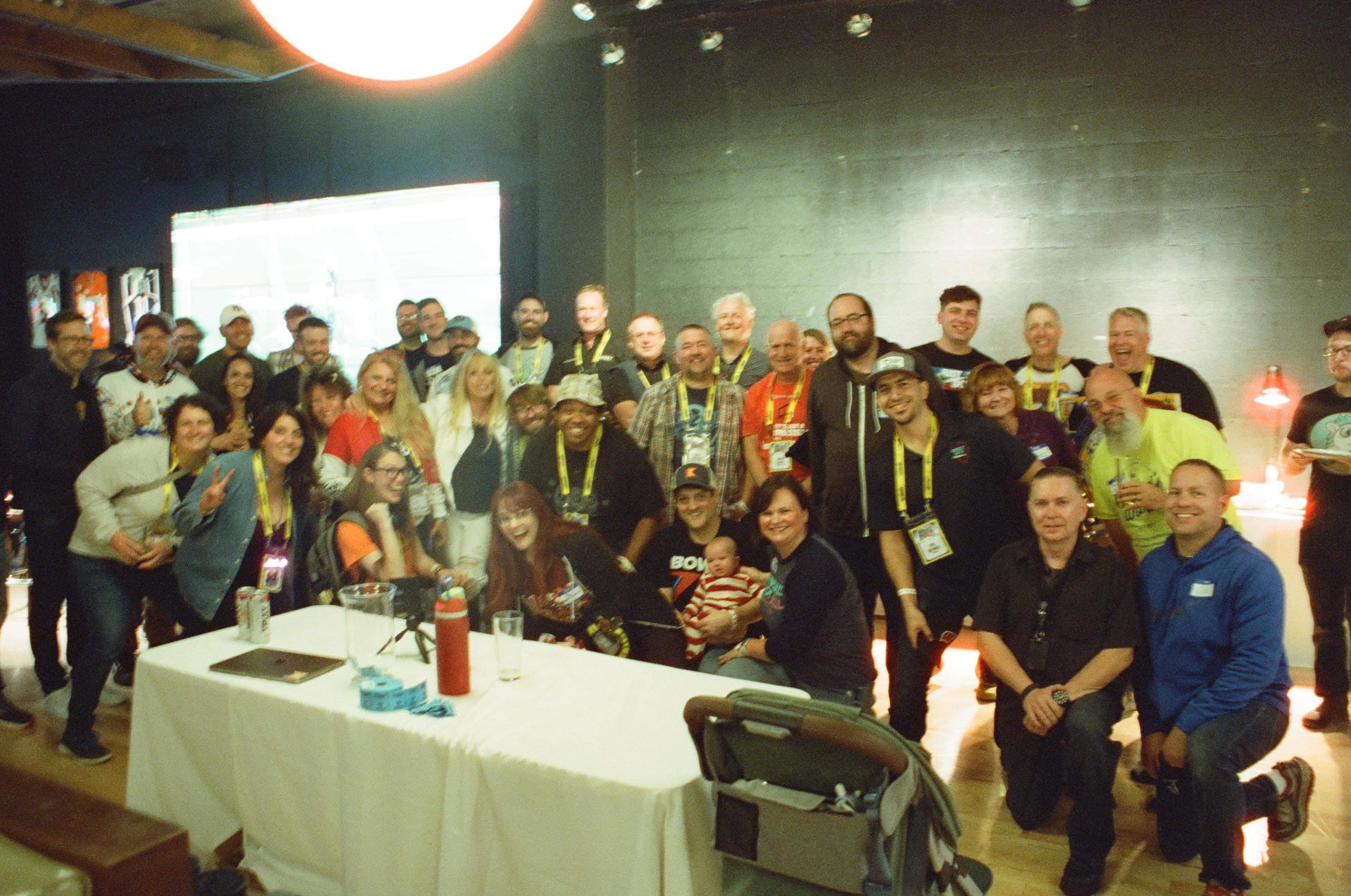Large group photo of conference attendees with name badges in event space