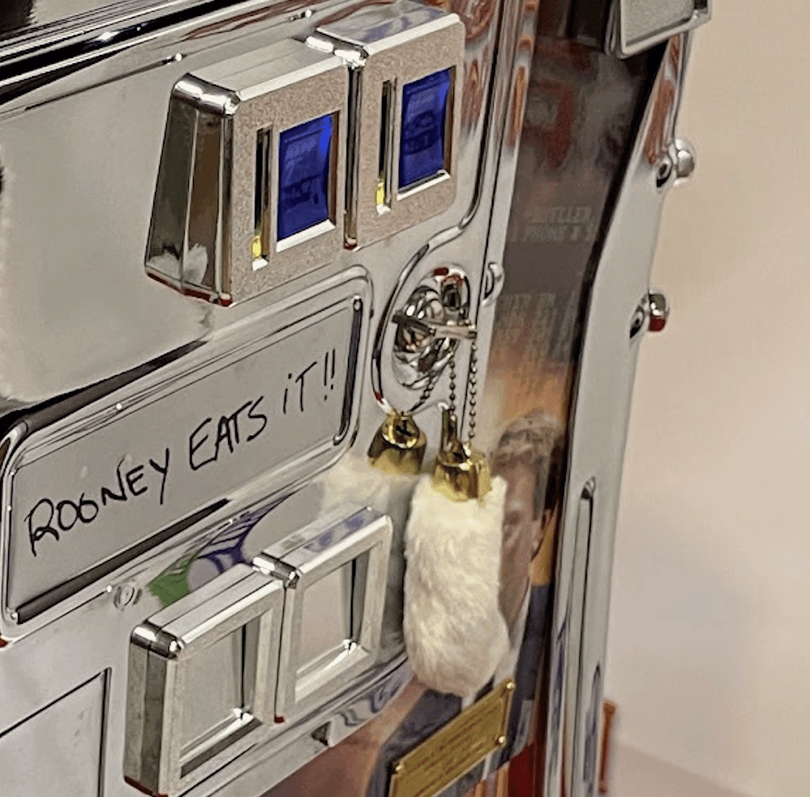 White mouse on metallic panel with "Rooney eats it!" handwritten text