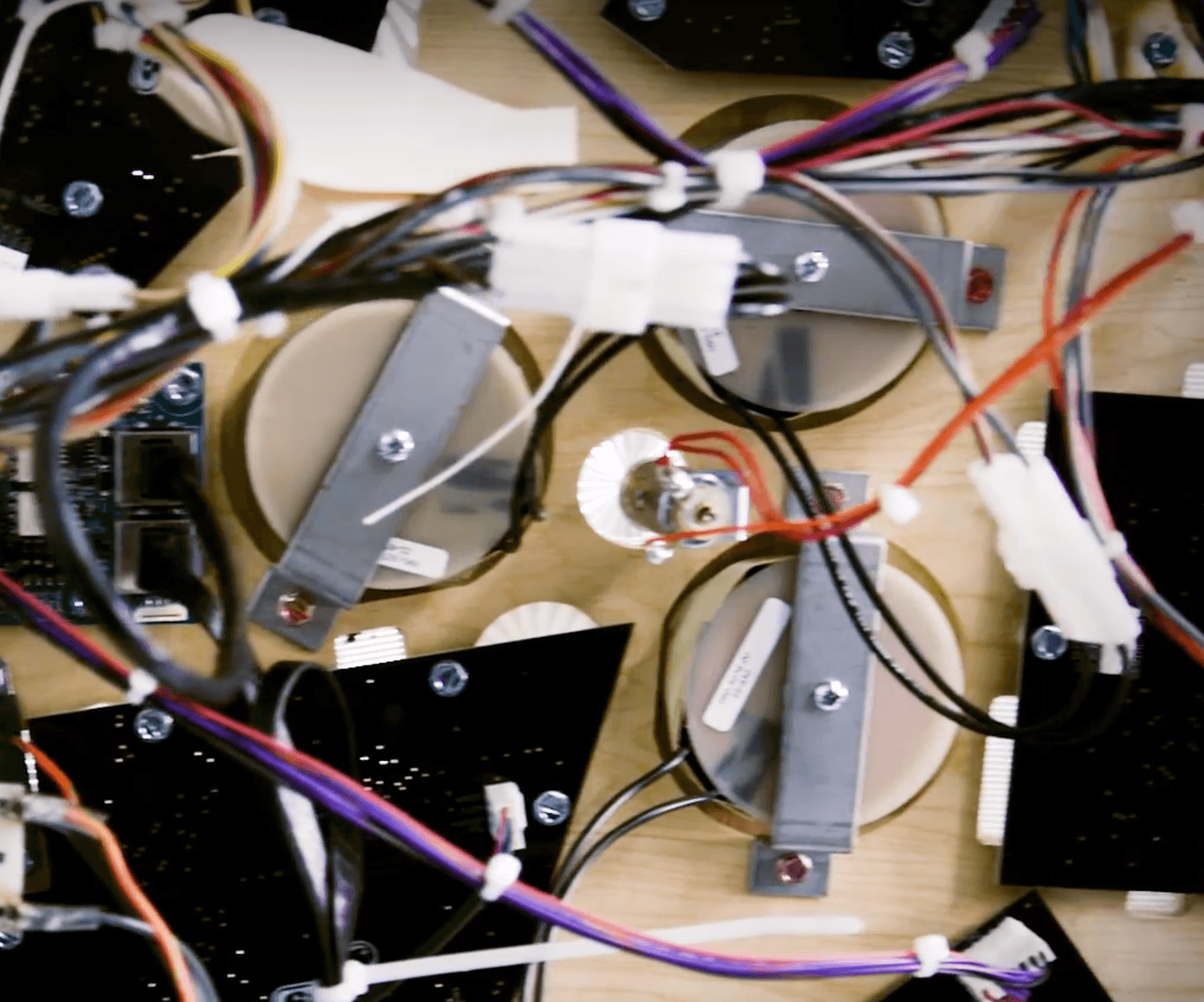 Tangled electronic components and wires on a wooden surface