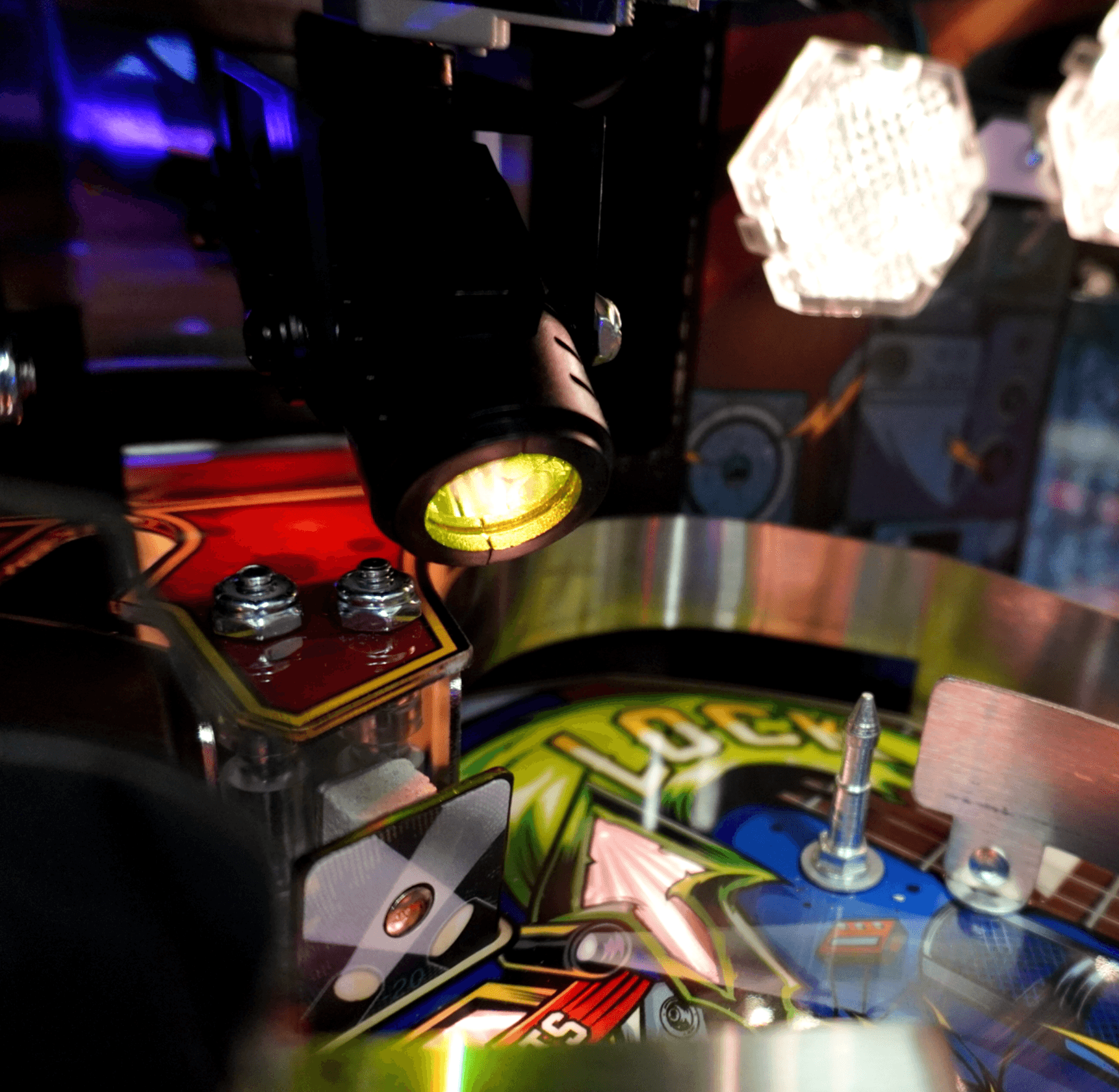 Pinball machine detail with colorful lights and mechanical components