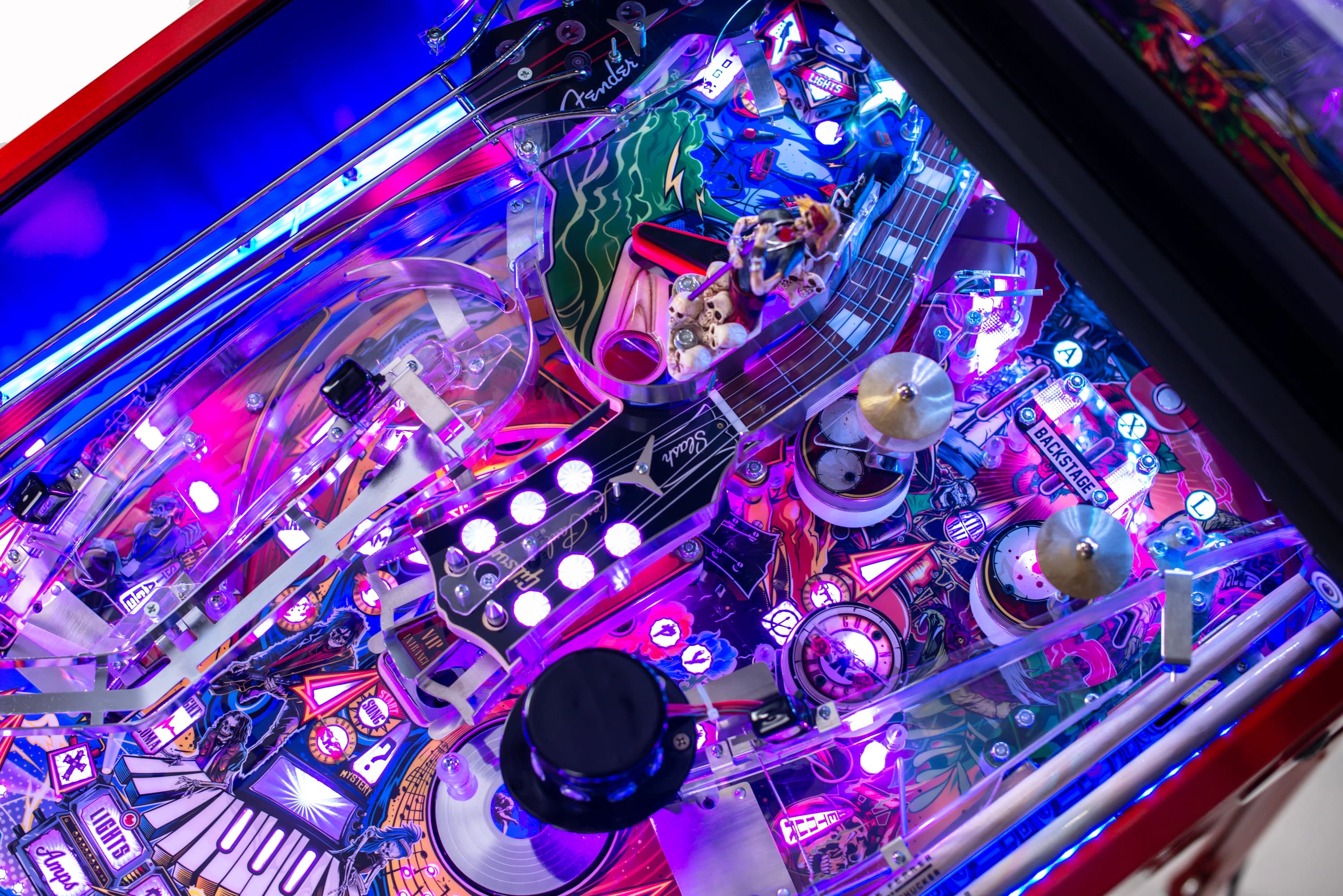 Colorful, illuminated pinball machine interior with musical instruments and lights