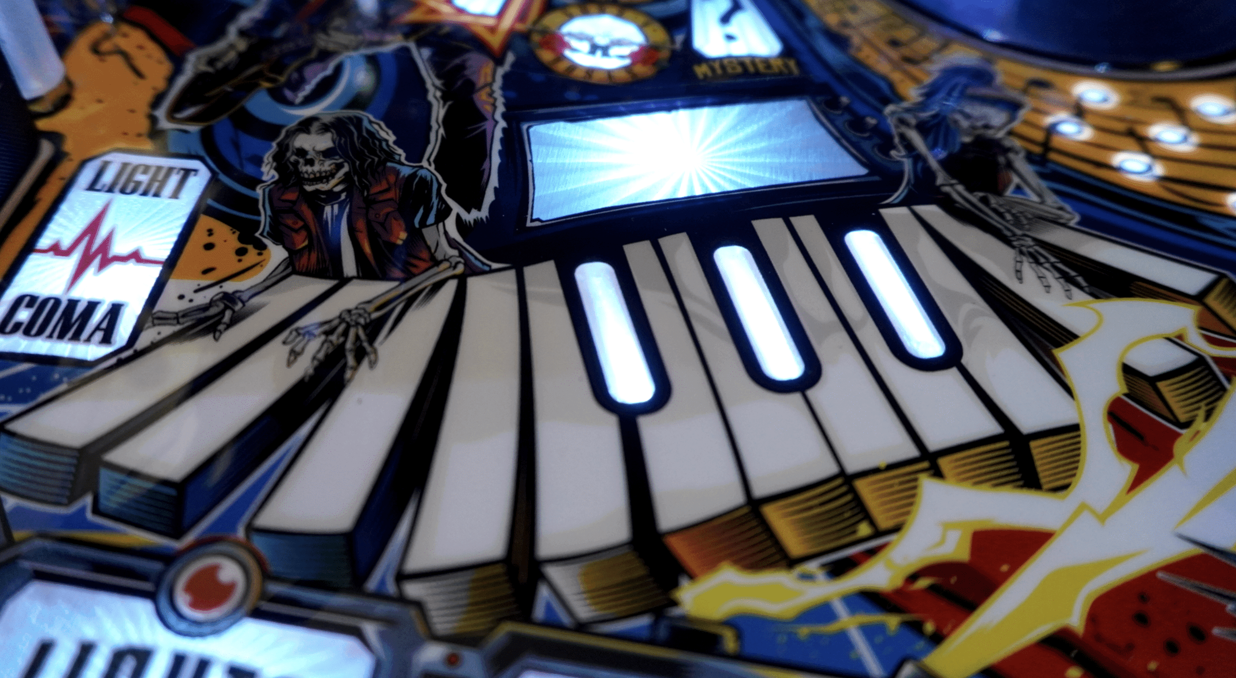 Pinball machine with skeleton figure, illuminated keys, and colorful graphic design