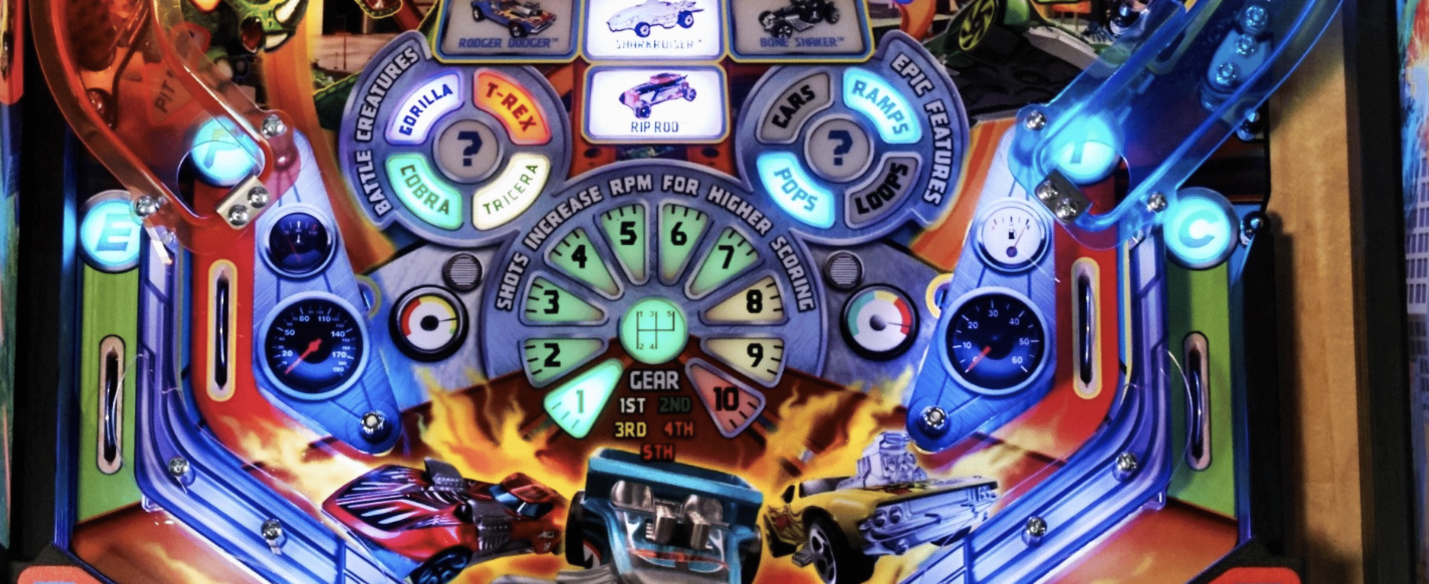 Colorful pinball machine dashboard with cars, gears, and flame background