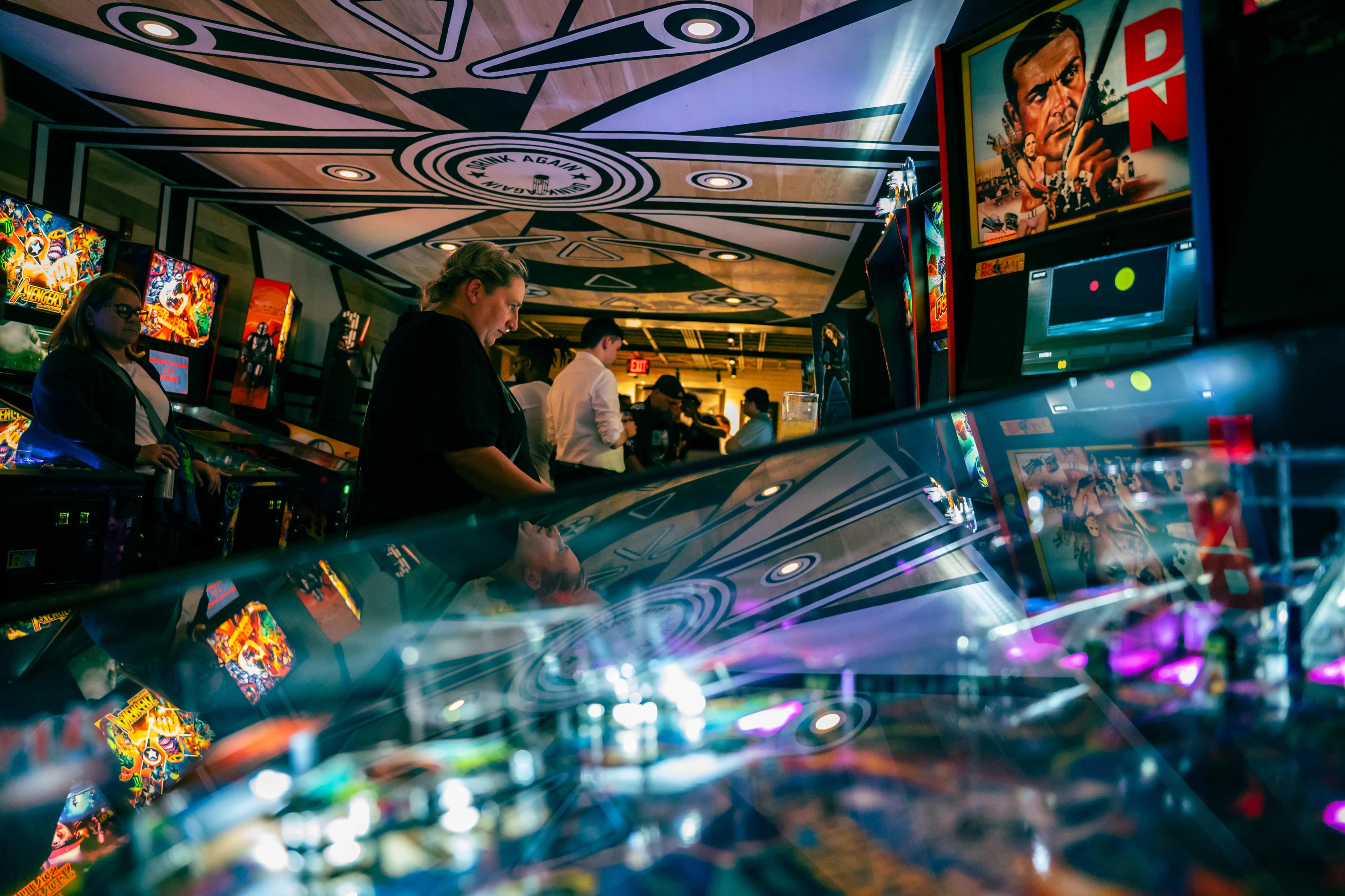 Colorful pinball arcade with vibrant machines and artistic ceiling design