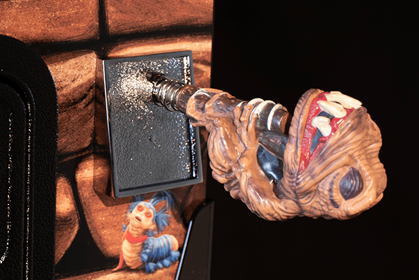 Alien creature breaking through wall with metallic drill-like appendage