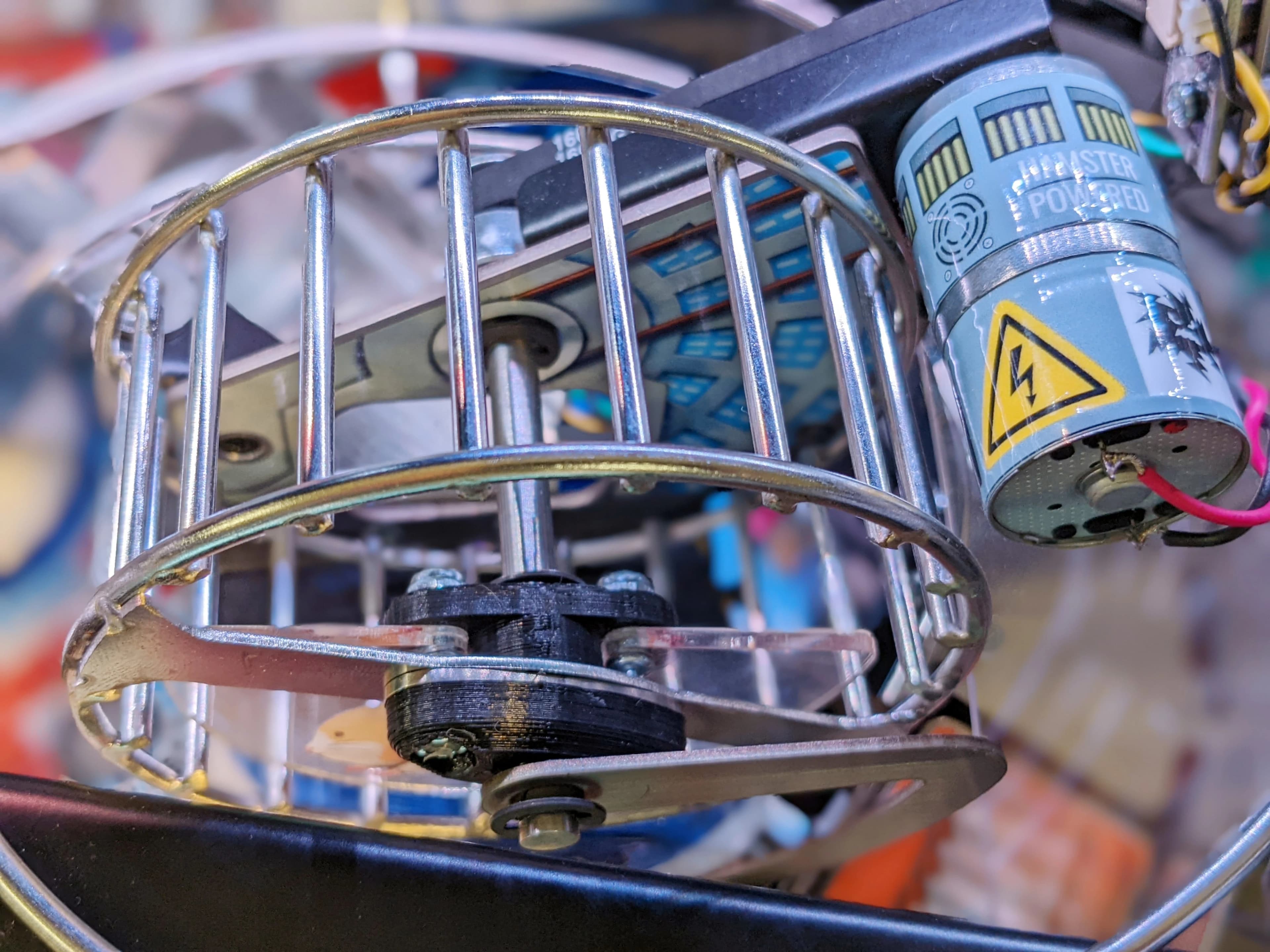 Mechanical device with metal cage, electrical components, and high-voltage warning