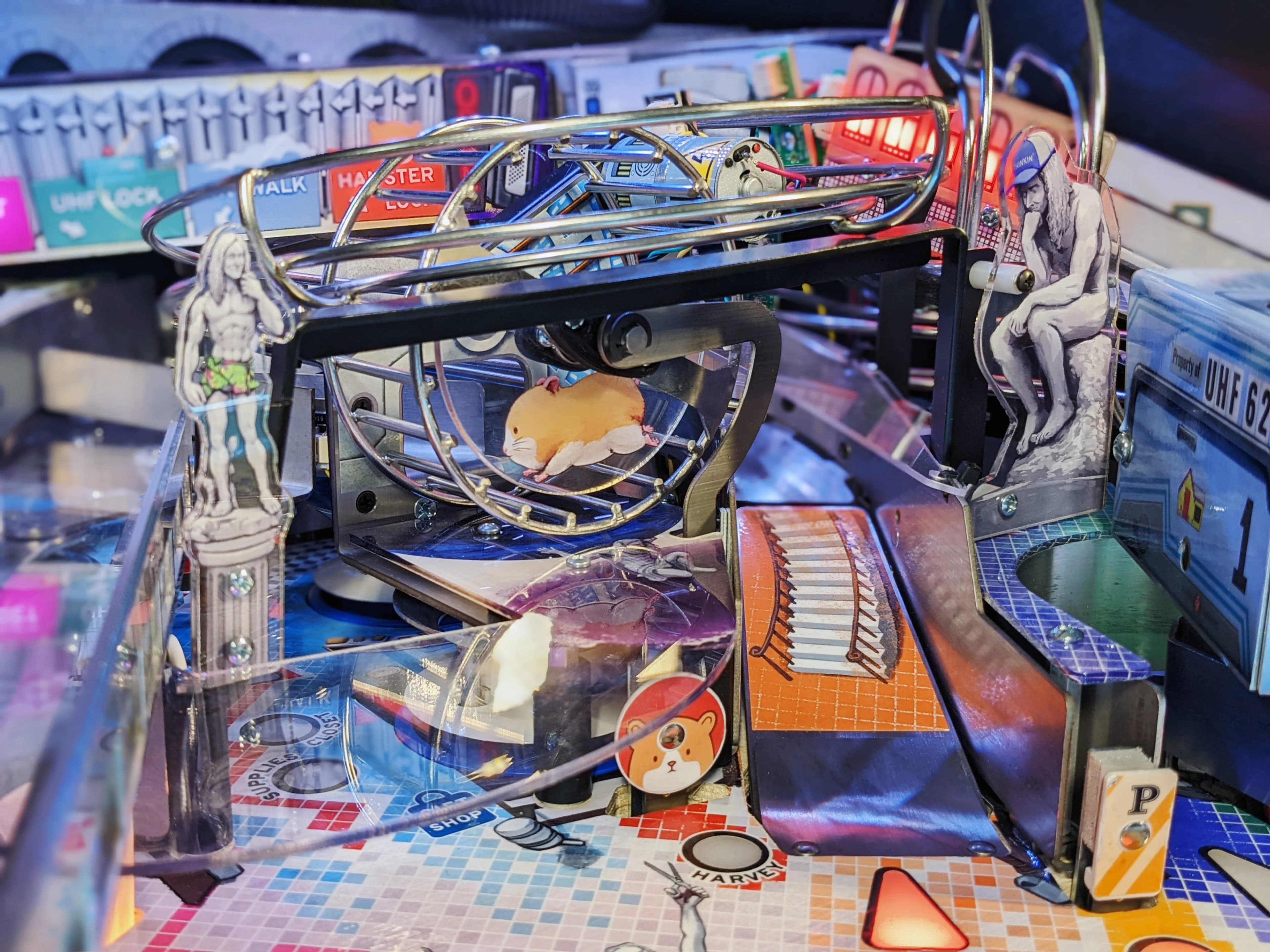 Hamster running on wheel in complex, colorful mechanical setup with graphic design