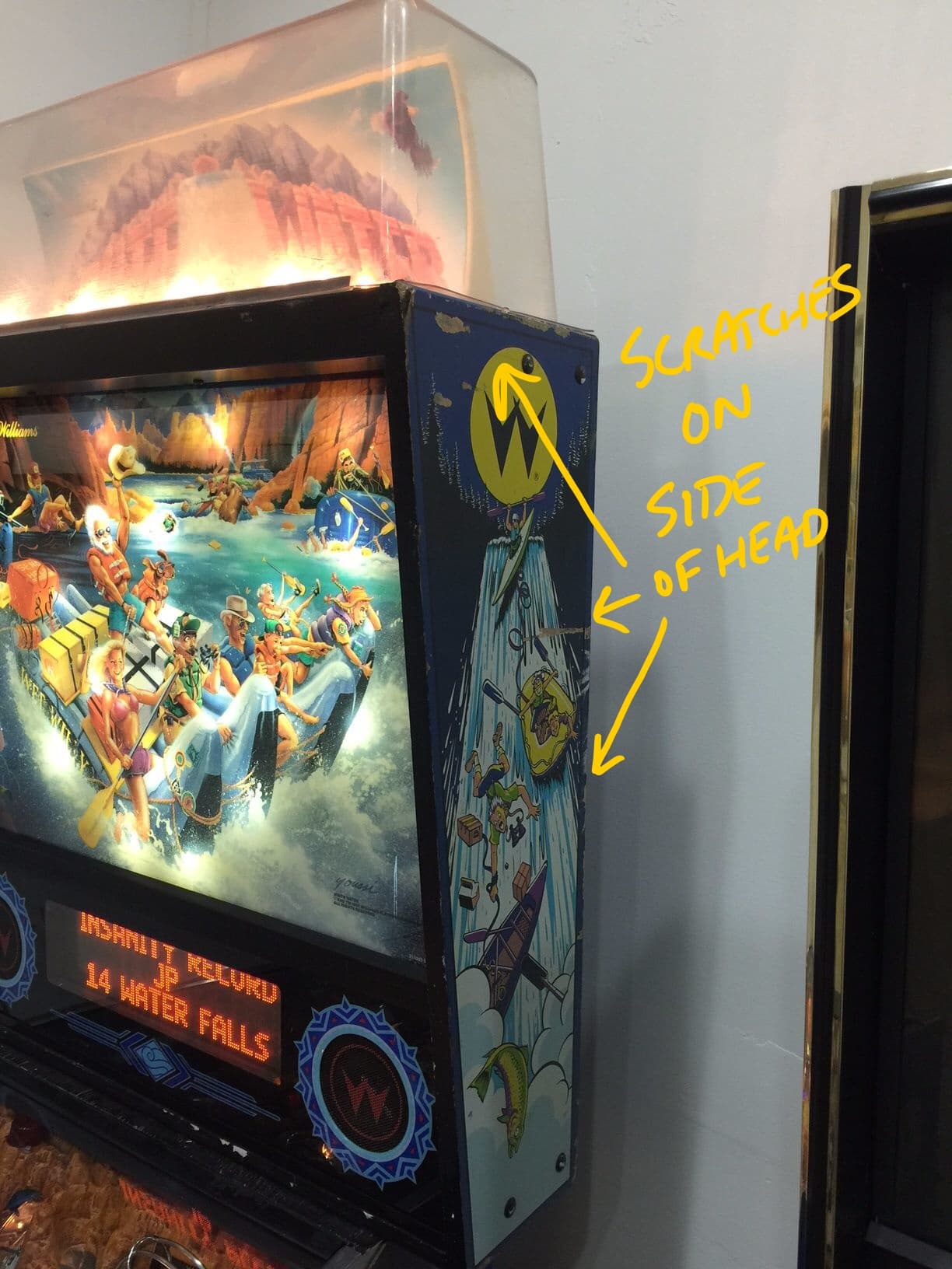 Vintage pinball machine with river rafting scene and water falls display