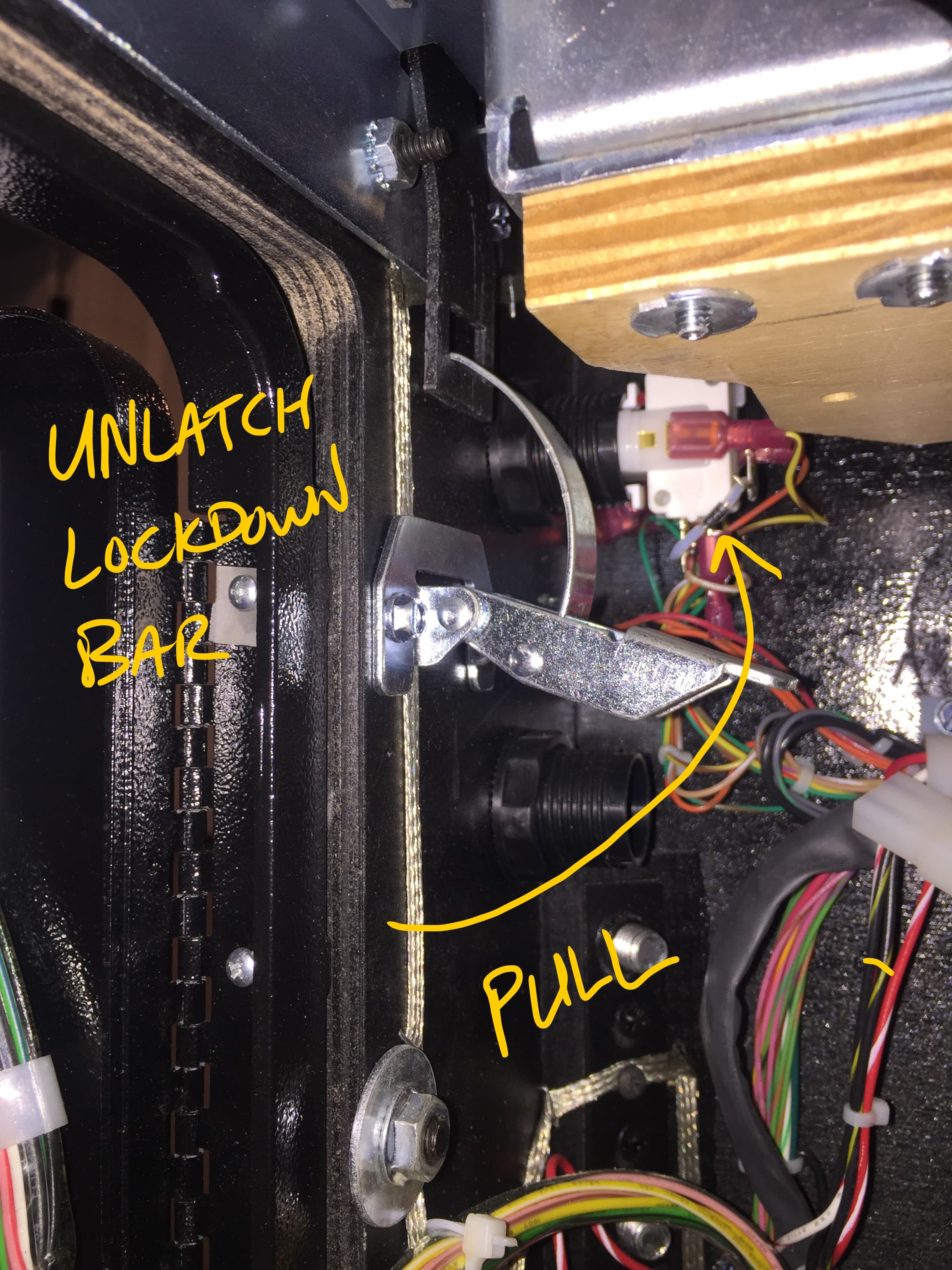 Close-up of mechanical device with unlatch lockdown bar and colorful wires