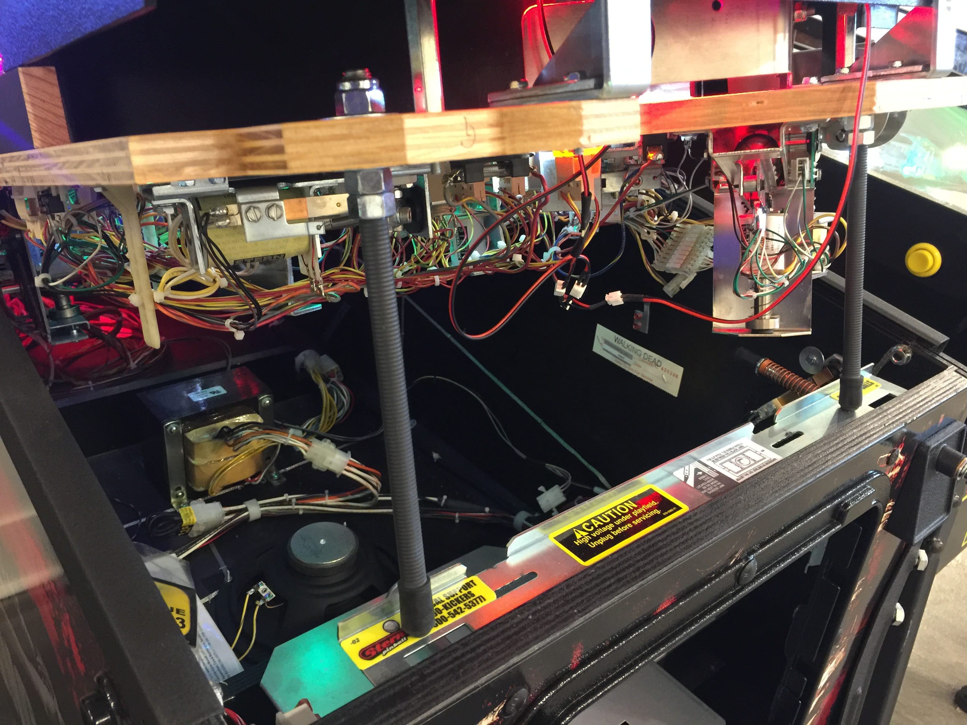 Complex electrical system with exposed wires, circuits, and warning labels