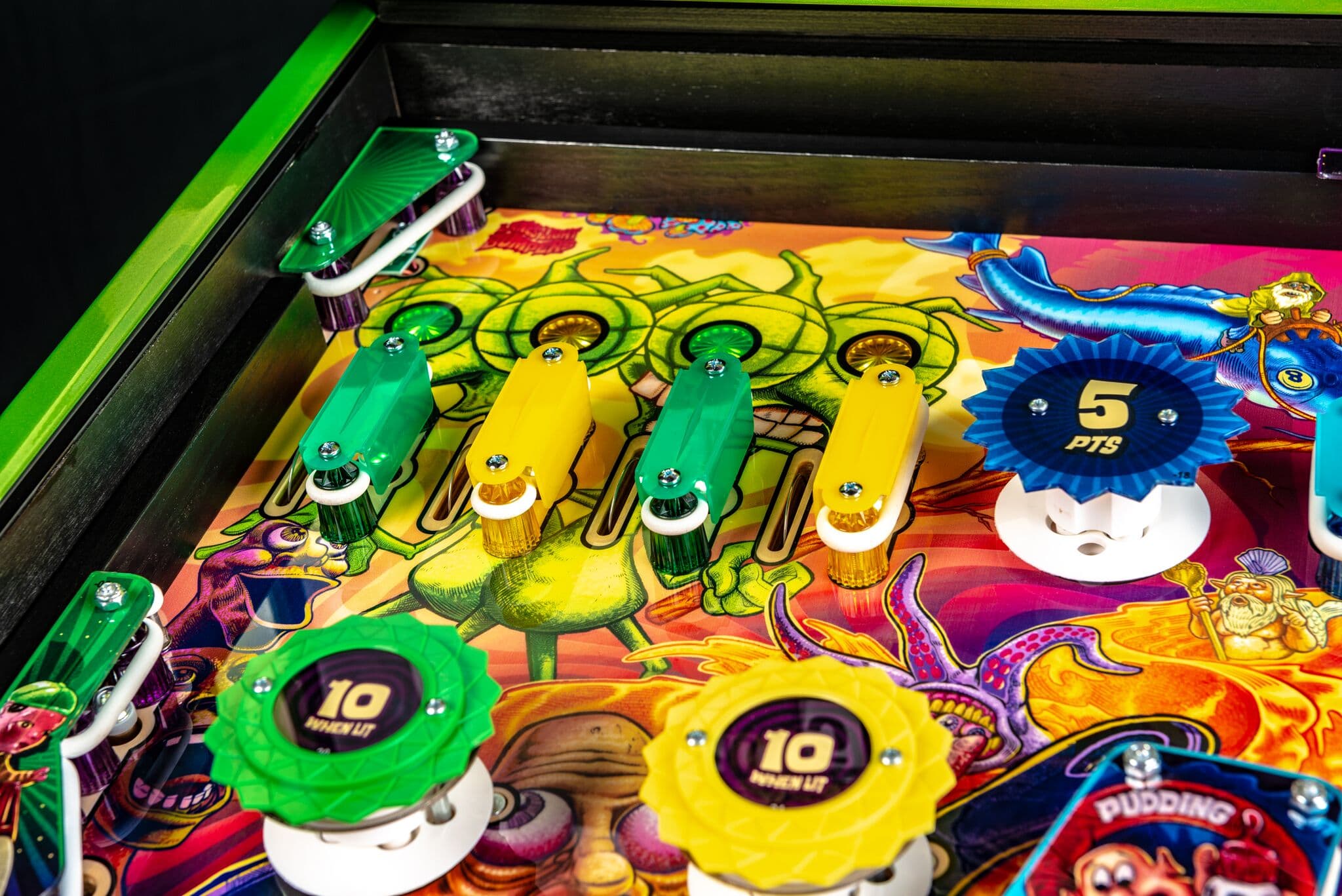 Colorful pinball machine with green and yellow bumpers and scoring targets